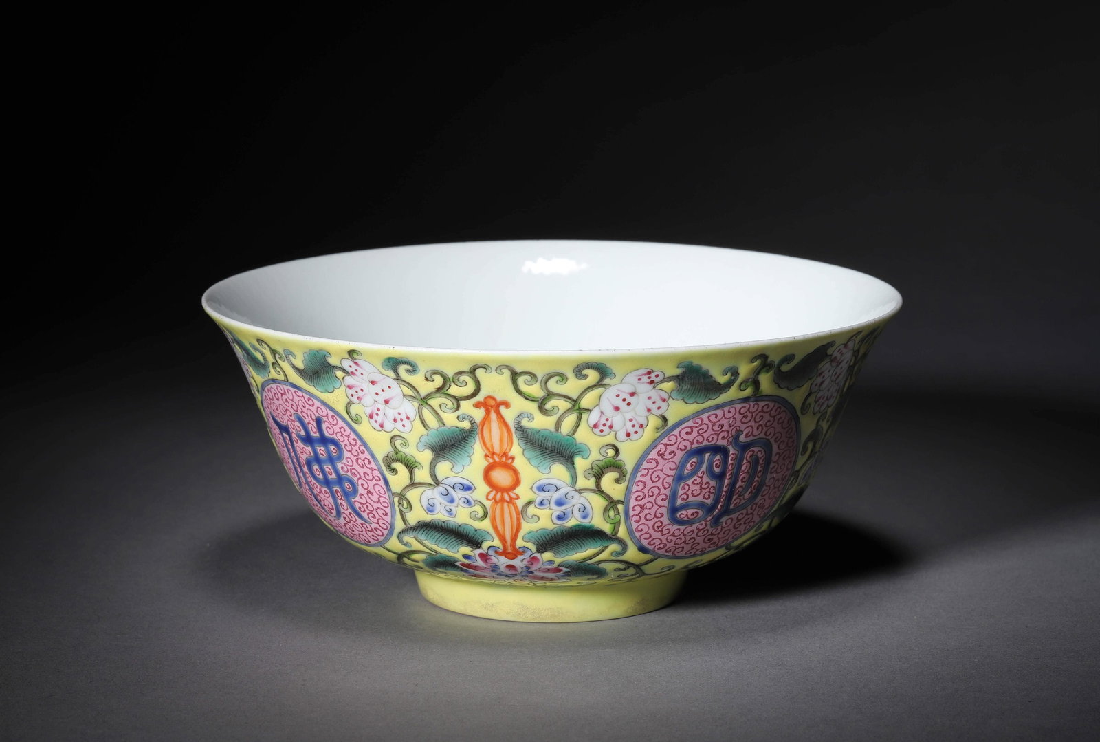 A FAMILLE ROSE YELLOW-GROUND BUDDHIST BOWL: A FAMILLE ROSE YELLOW-GROUND BUDDHIST BOWL Width:15.5cm, Height:7cm, Condition: Overall good condition commensurate with age, with usual traces of wear.