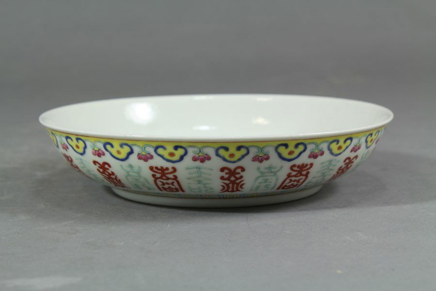 Famille Rose Dish: Colorful Famille Rose porcelain dish with Ruyi borders and auspicious symbols of fortune. The interior with copper magic bats and shou symbols, six figure seal mark on base. Diameter 6.5"