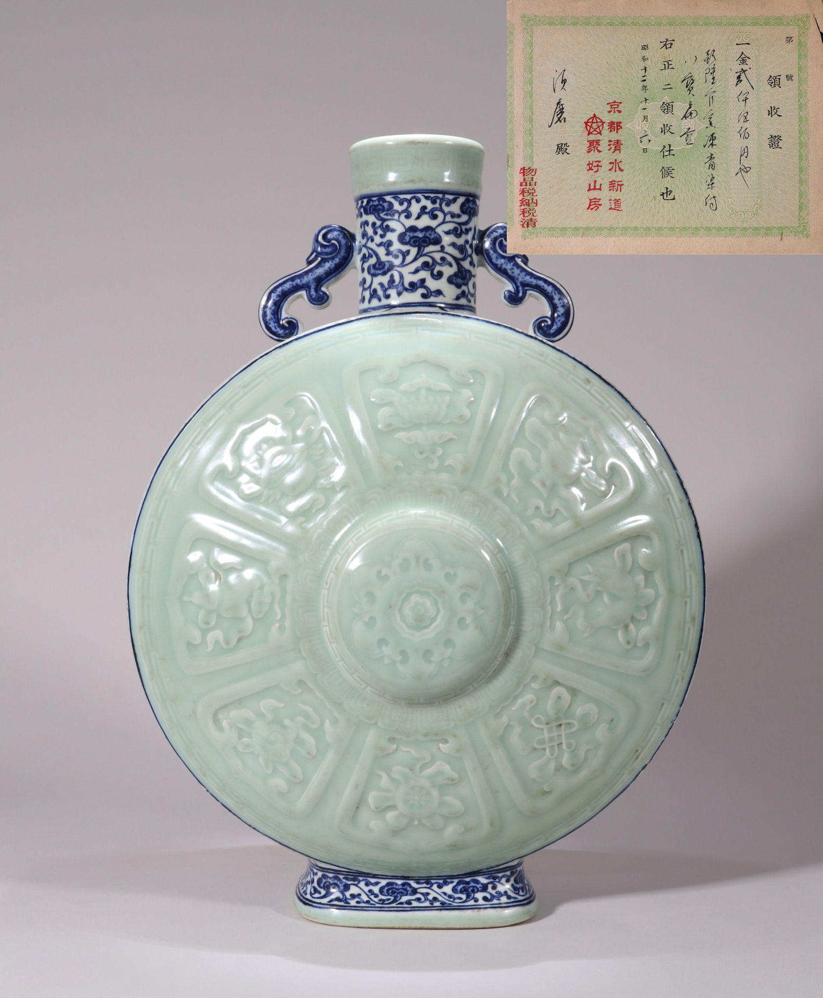 A BLUE AND WHITE AND CELADON-GLAZED 'EIGHT BUDDHIST EMBLEMS' FLASK: A Large Pilgrim Flask decorated with the Eight Buddhist Emblems (Bajixiang) in underglaze blue on a celadon-glazed ground. H. 49 cm.