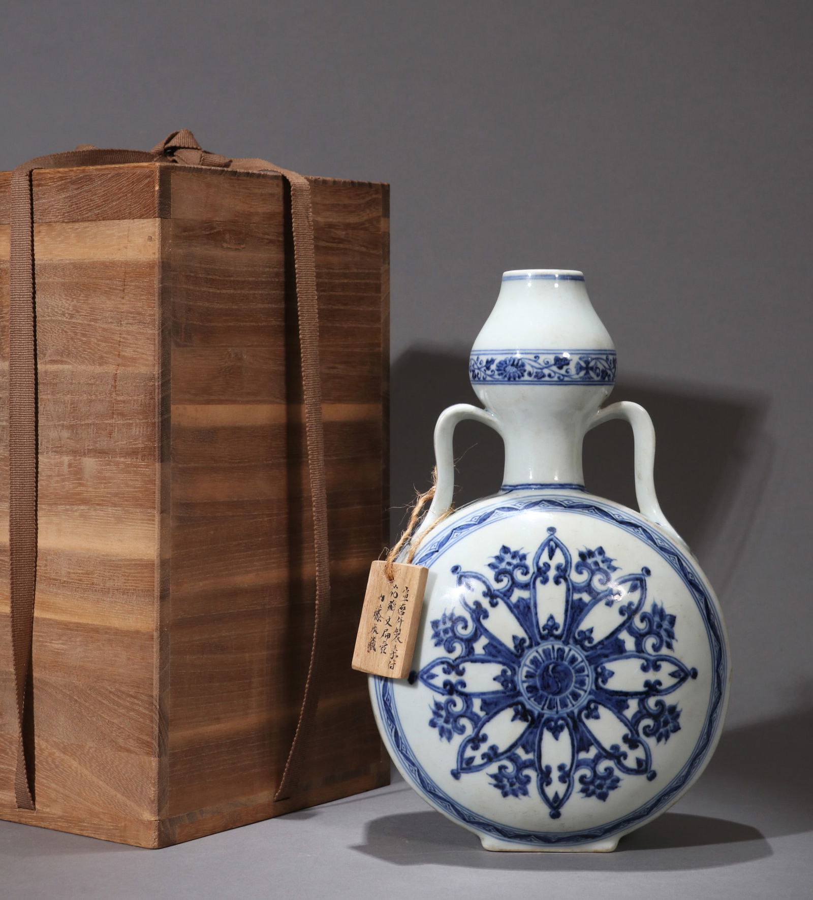 A BLUE-AND-WHITE 'FLORAL SCROLL' MOON FLASK: A blue-and-white moon flask (baoyueping) decorated with a floral scroll motif. H. 26 cm.