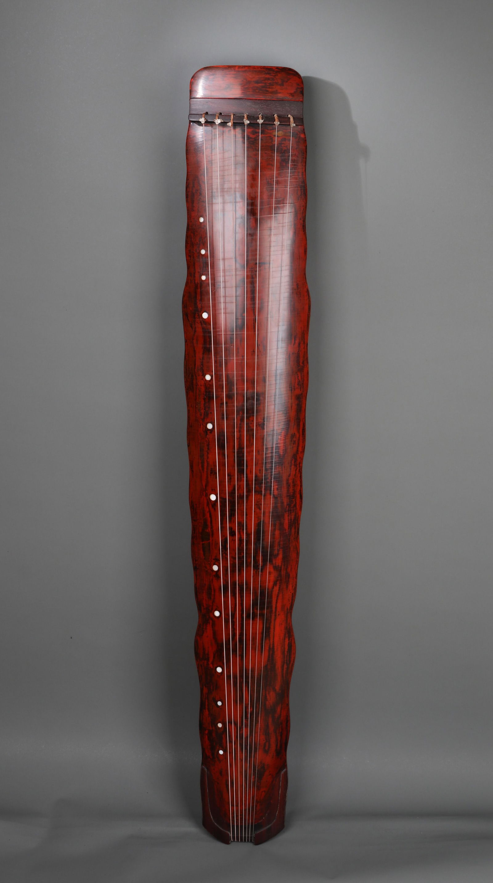 A 'RUANZHU' STYLE GUQIN: A guqin of 'Ruanzhu' style with a red lacquer finish. L. 122 cm.