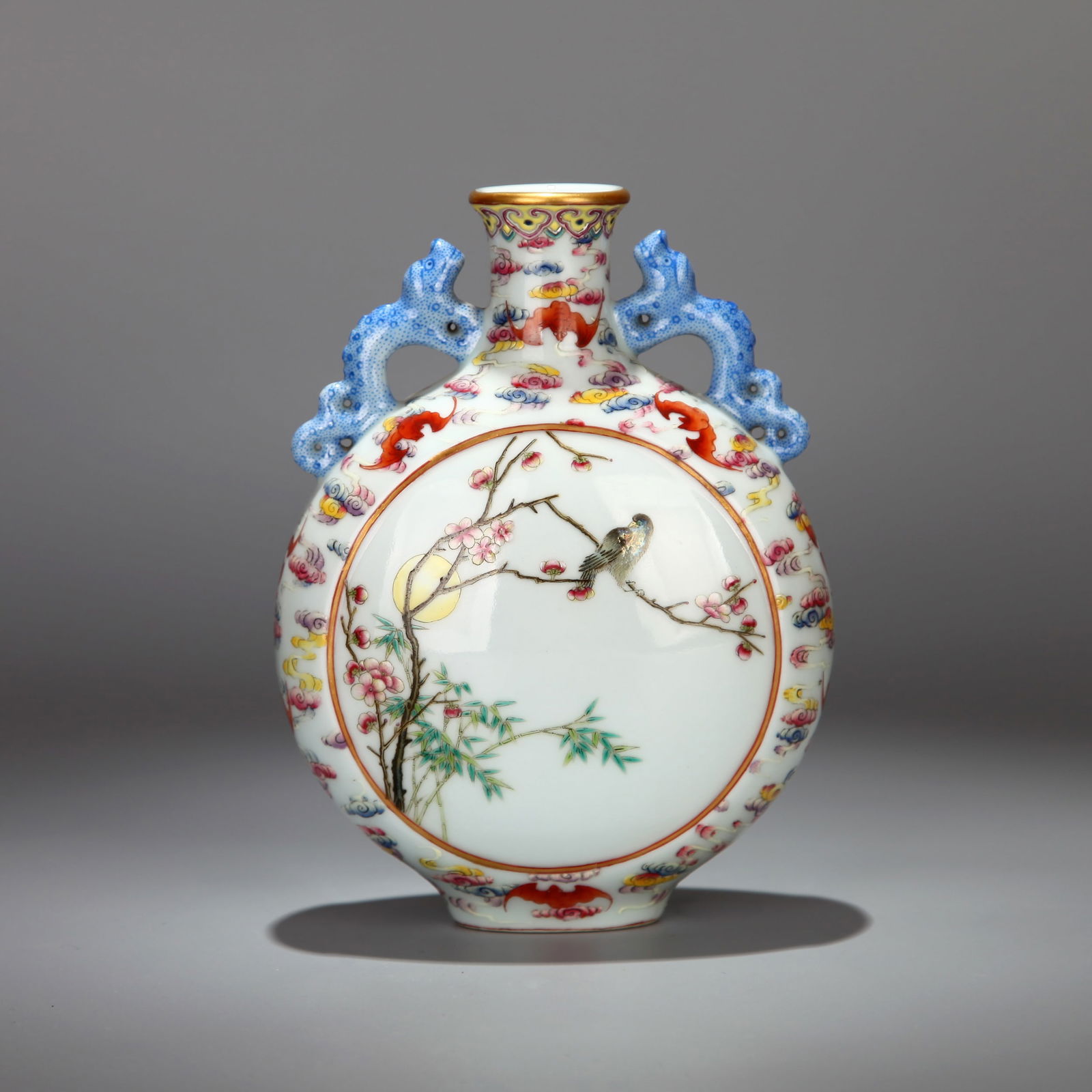 A FAMILLE-ROSE 'FLOWER AND BIRD' TWIN-DRAGON MOONFLASK: A moonflask decorated with panels of flowers and birds in famille-rose enamels, flanked by a pair of dragon handles. H. 16 cm.