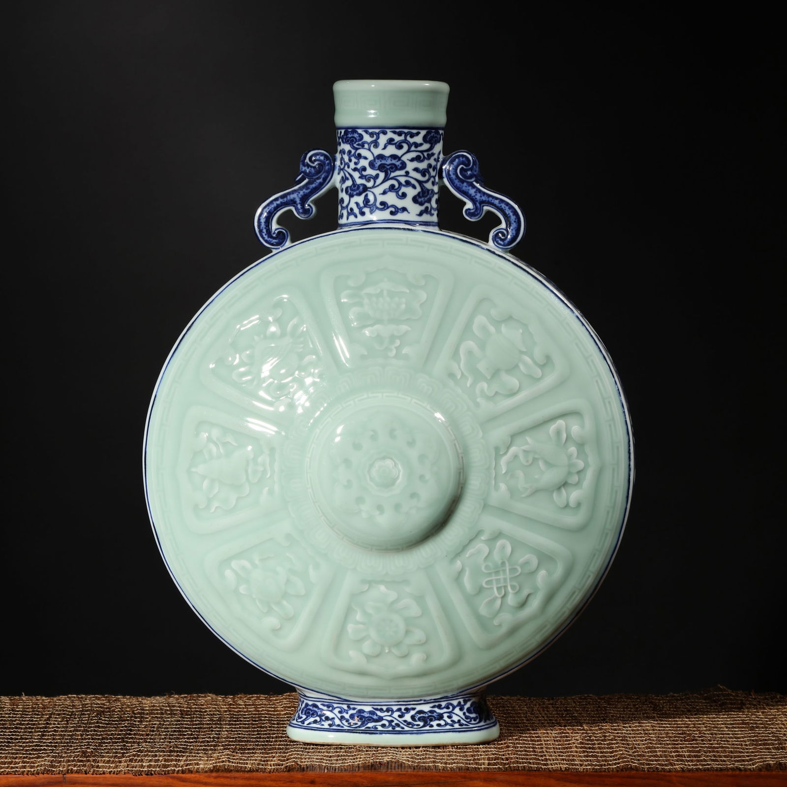 CELADON GLAZE AND UNDERGLAZE BLUE EIGHT TREASURES MOON FLASK: Celadon glaze and underglaze blue Eight Treasures moon flask. Height: 47 cm, Width: 37 cm.