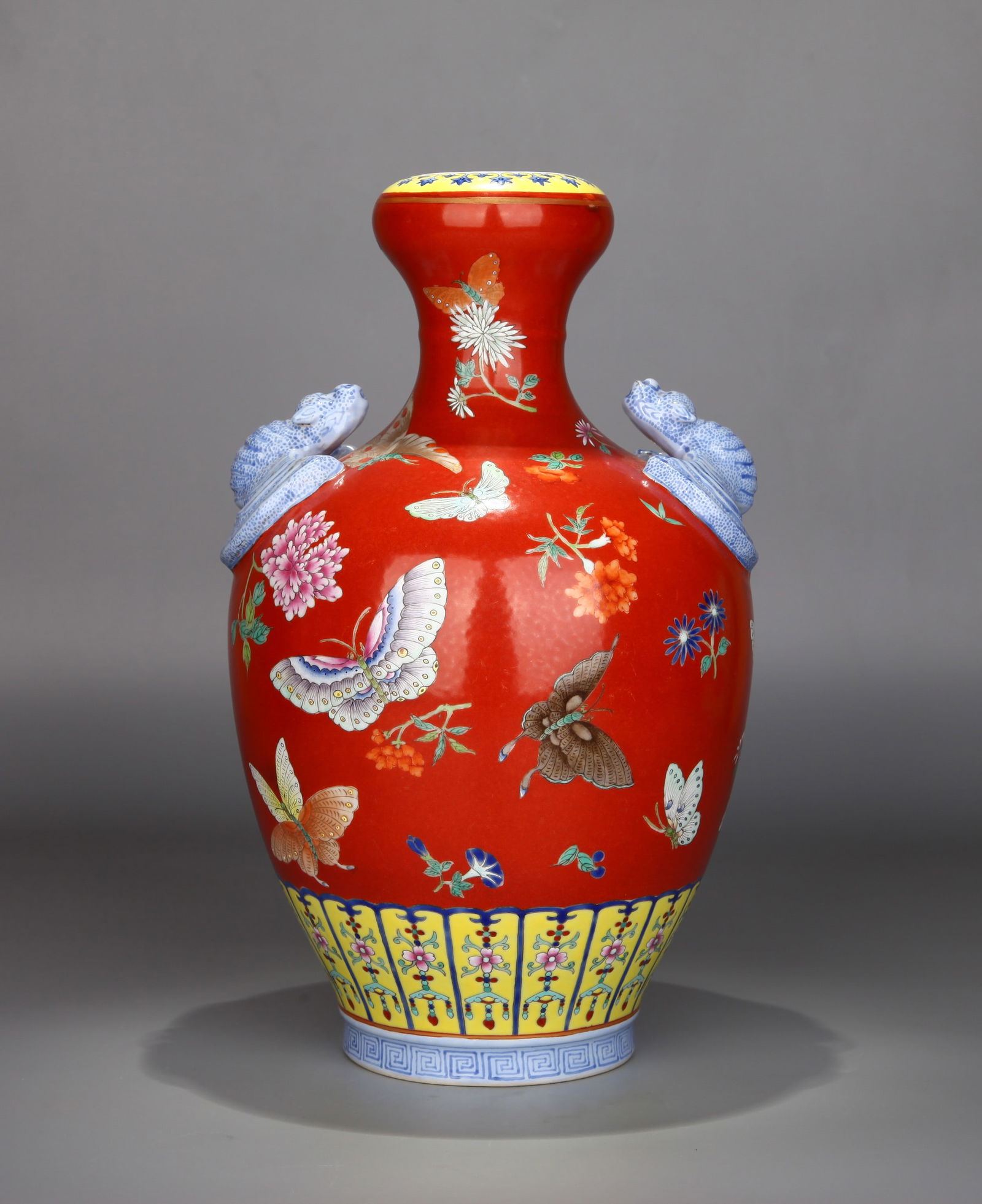 A RED-GROUND FAMILLE-ROSE GARLIC-MOUTH VASE: A red-ground famille-rose garlic-mouth vase decorated with bats, flowers and butterflies. Height 31 cm.