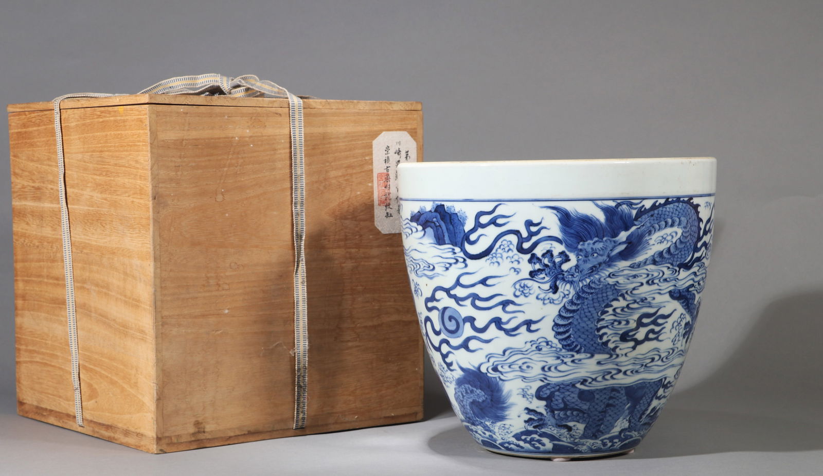 A BLUE AND WHITE 'DRAGON' VAT: A blue and white vat decorated with seawater and dragon design. Diameter 29 cm, Height 26 cm.Note: By repute, from the collection of Kawasaki Baron and Nozu.