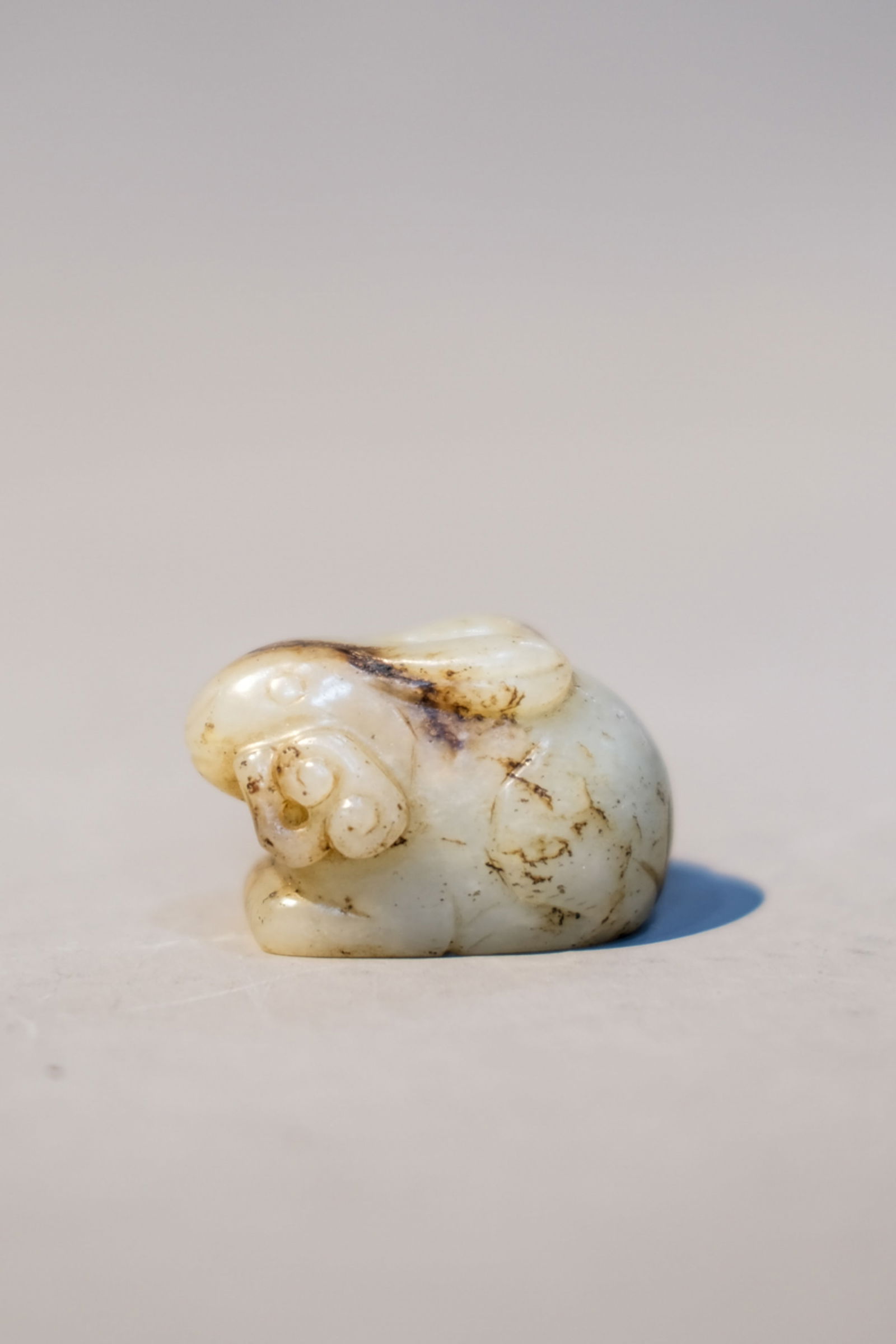 RUSSET JADE RABBIT ORNAMENT: Russet jade rabbit ornament. Dimensions: Length: 4.5 cm, Height: 2.8 cm.