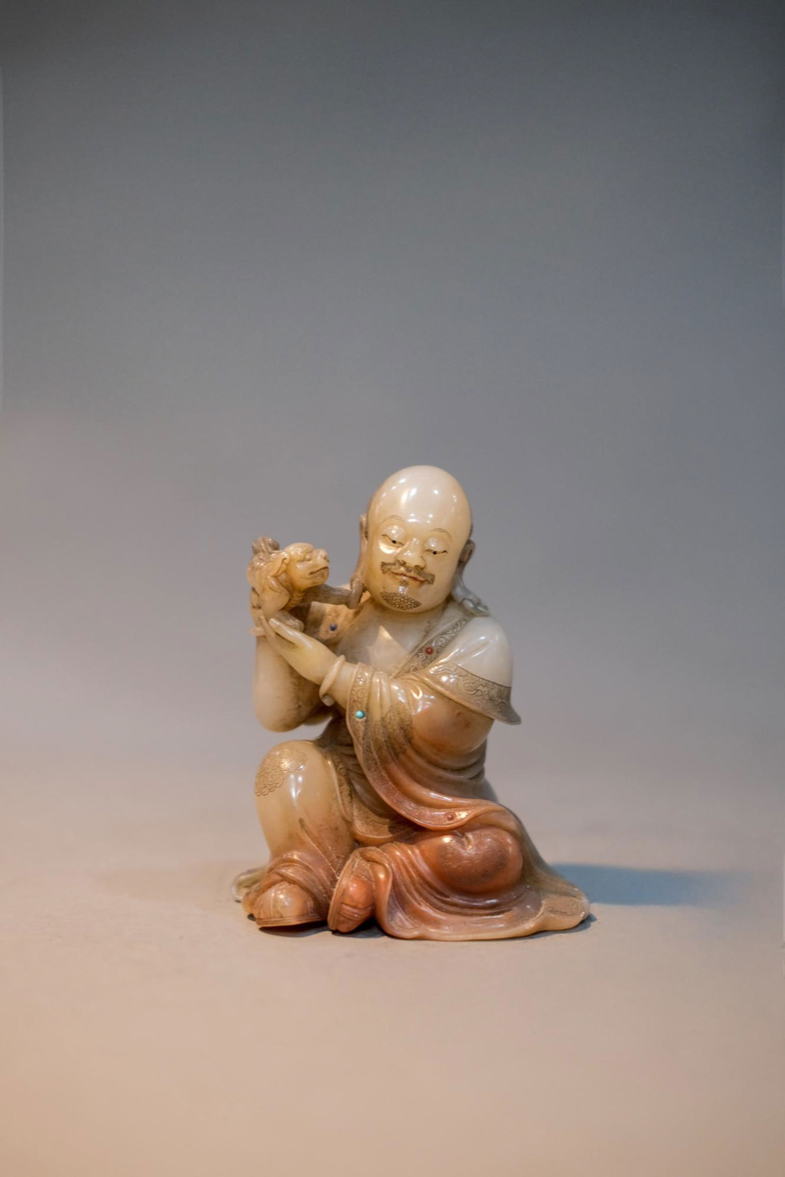CARVED SHOUSHAN STONE IMMORTAL STATUE: Carved Shoushan stone immortal statue.Dimensions: Height: 10 cm, Width: 8 cm.