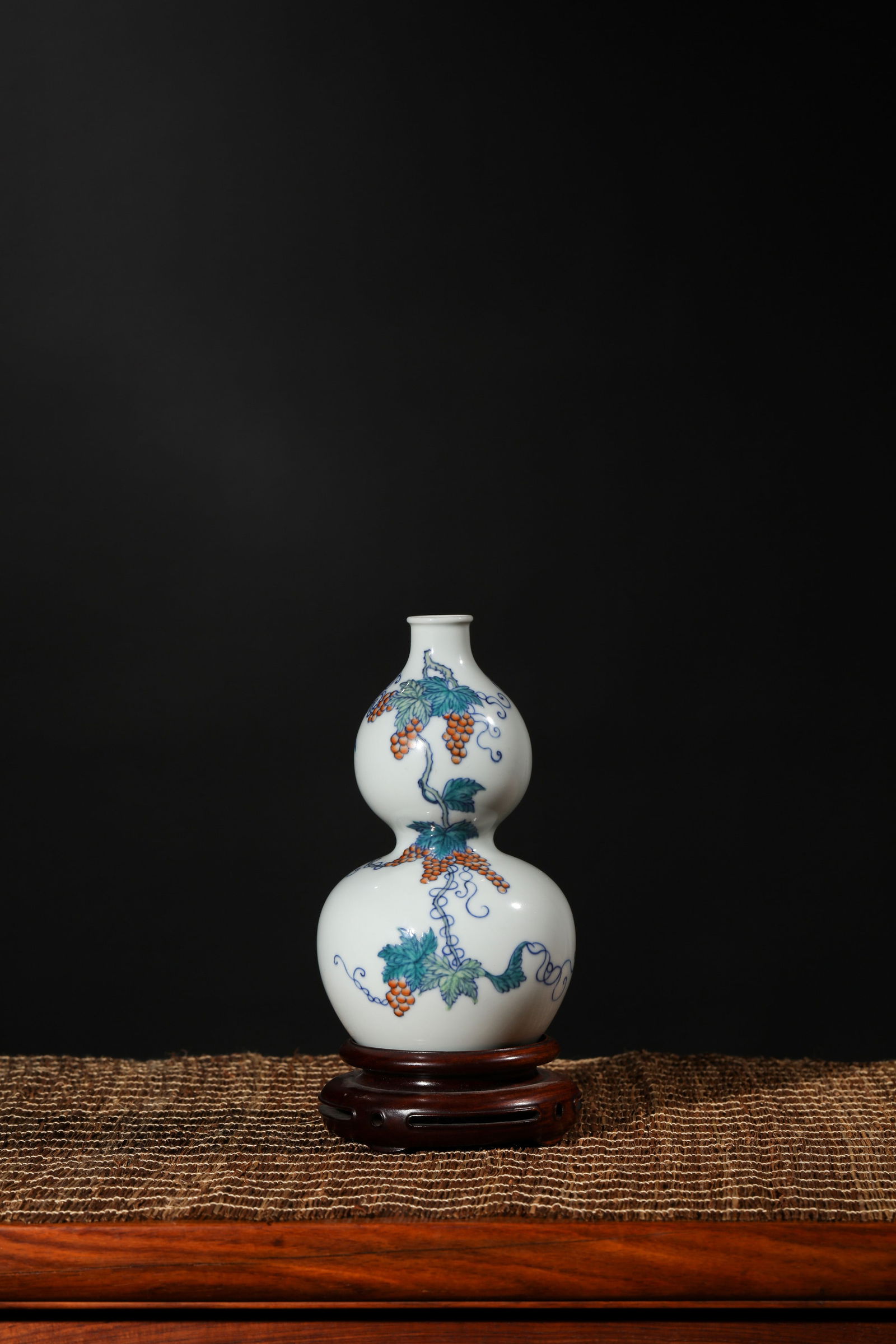 DOUCAI GLAZE GRAPE AND SQUIRREL DOUBLE-GOURD-SHAPE VASE: Doucai glaze Grape and Squirrel double-gourd-shape vase.Dimensions: Height: 17 cm, Width: 9.9 cm.