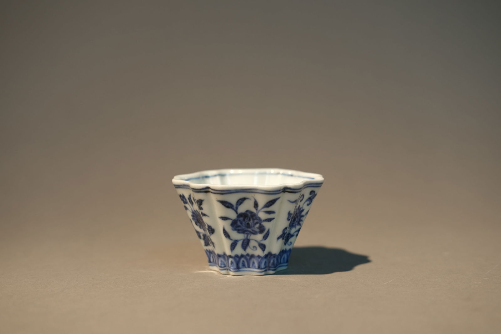 BLUE AND WHITE FLOWER BARBED-RIM CUP: Blue and white flower barbed-rim cup. Dimensions: Height: 5.2 cm, Diameter: 8.5 cm.