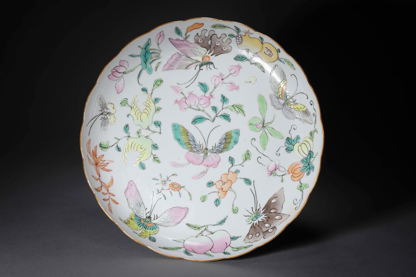 FAMILLE ROSE MELON AND BUTTERFLY SAUCER PLATE: Famille rose melon and butterfly saucer plate. Dimensions: Width: 24.5 cm, Height: 3.5 cm.