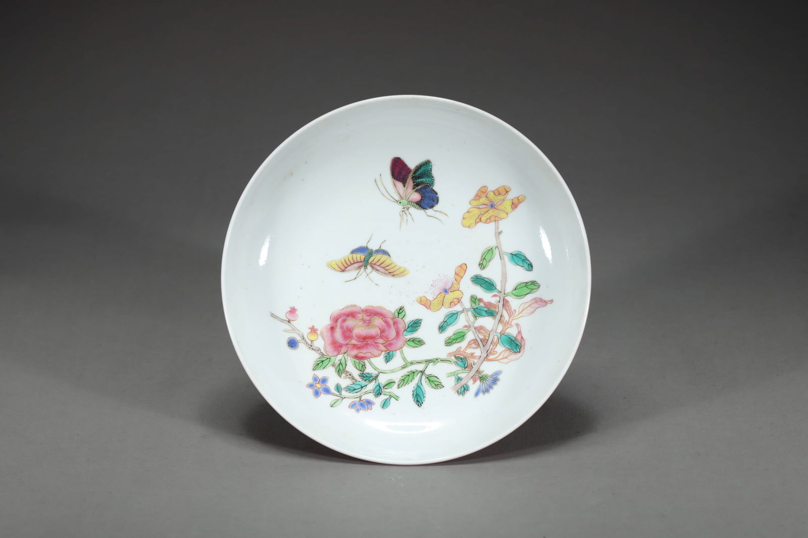 QING ROUGE-RED-GLAZED FAMILLE ROSE BUTTERFLY AND FLOWER DISH: Qing rouge-red-glazed famille rose butterfly and flower dish. Dimensions: Height: 3.4 cm, Diameter: 15.8 cm.