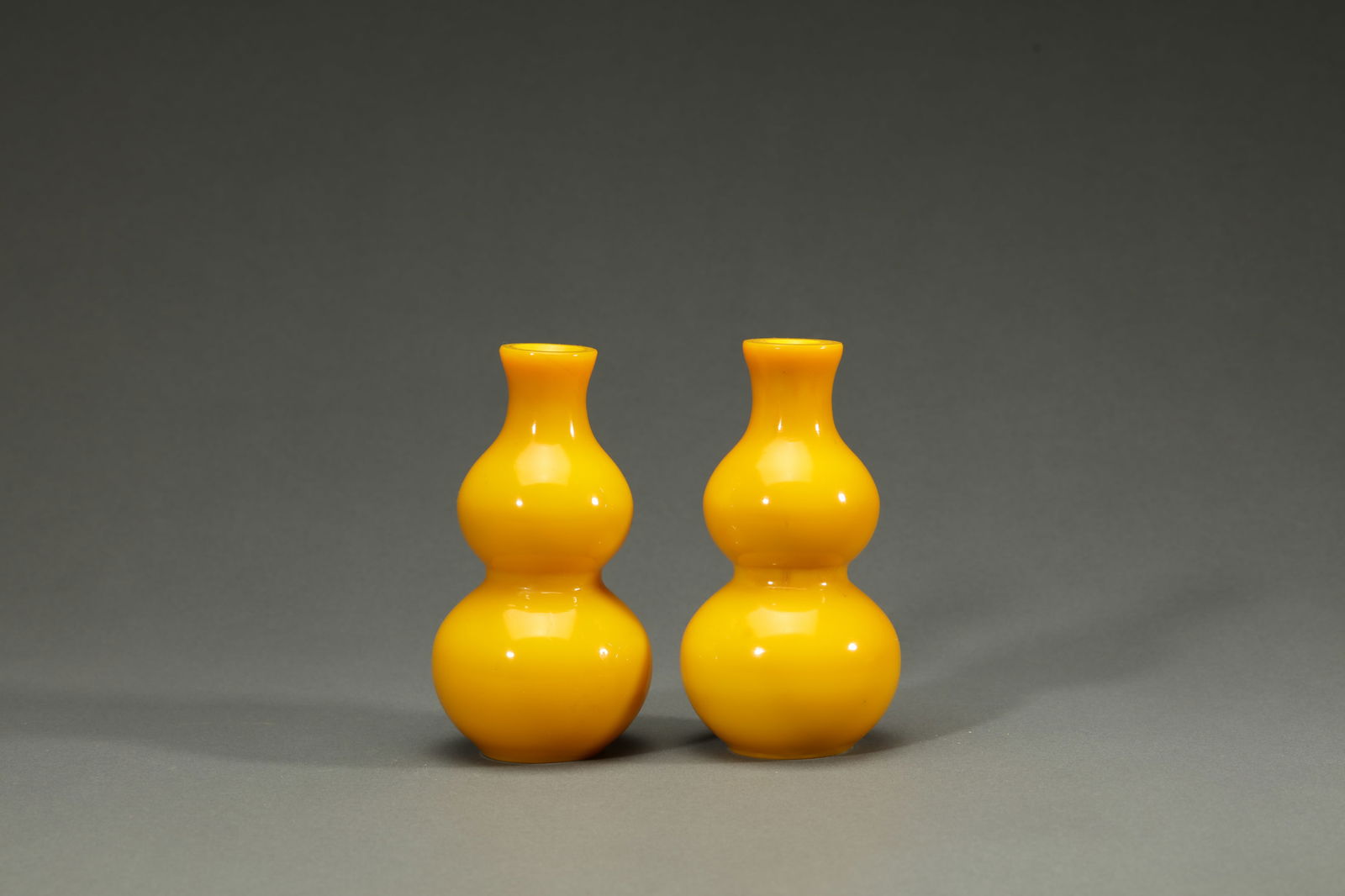 PAIR OF YELLOW GLASSWARE DOUBLE-GOURD-SHAPE VASES: Pair of yellow glassware double-gourd-shape vases.Dimensions: Height: 14.5 cm, Width: 8 cm.
