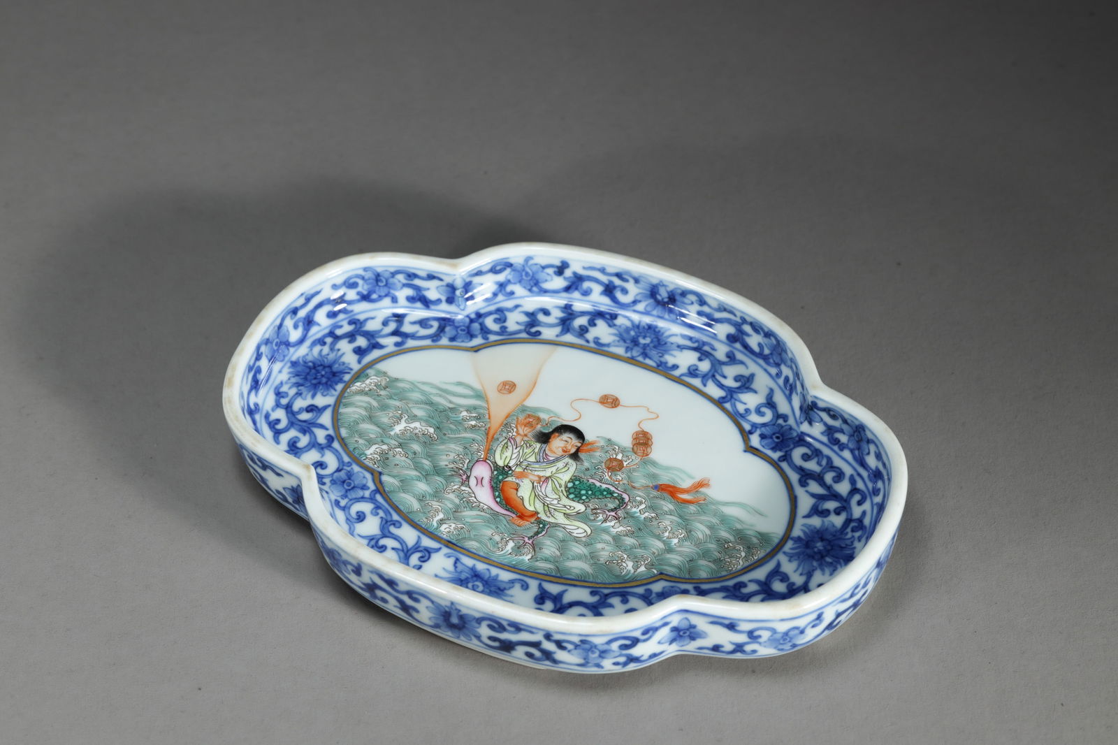 UNDERGLAZE BLUE AND FAMILLE ROSE FIGURE BEGONIA-SHAPE BRUSH WASHER: Underglaze blue and famille rose figure begonia-shape brush washer.Dimensions: Length: 17 cm, Width: 11.5 cm.