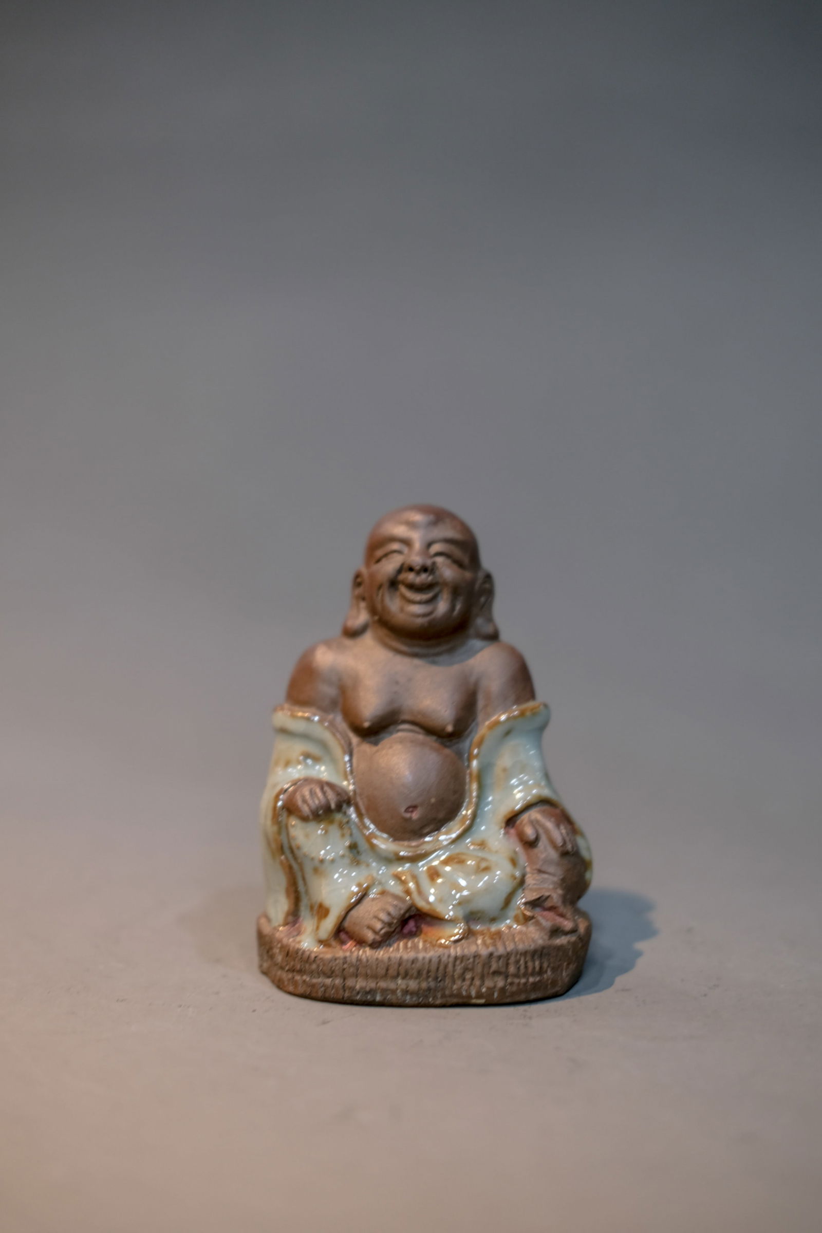 CELADON GLAZE MONK FIGURINE: Celadon glaze monk figurine. Dimensions: Height: 10 cm, Width: 7 cm.