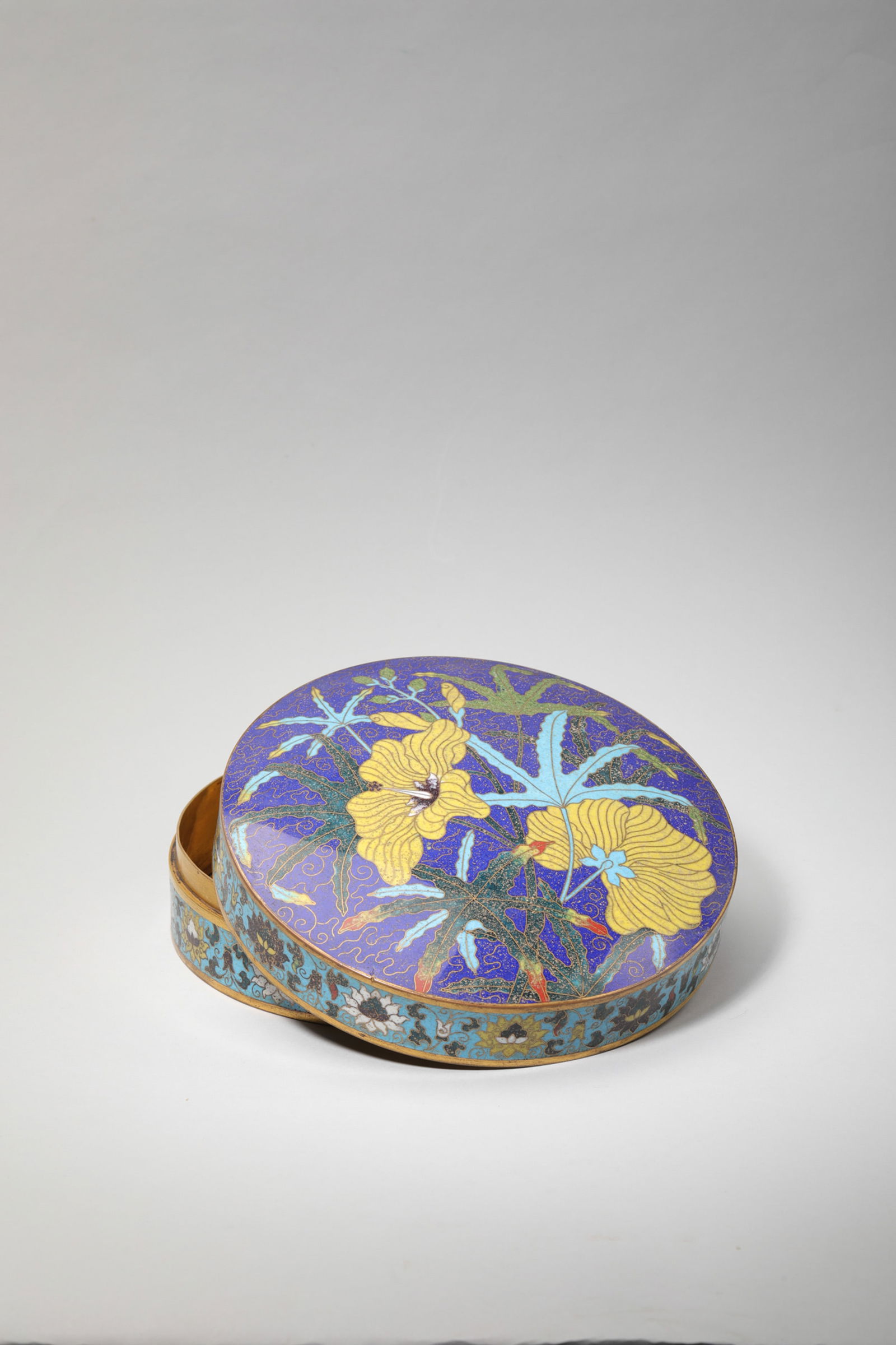CLOISONNE ENAMEL FLOWER CIRCULAR BOX AND COVER: Cloisonne enamel flower circular box and cover. Dimensions: Diameter: 18.6 cm, Height: 7 cm.