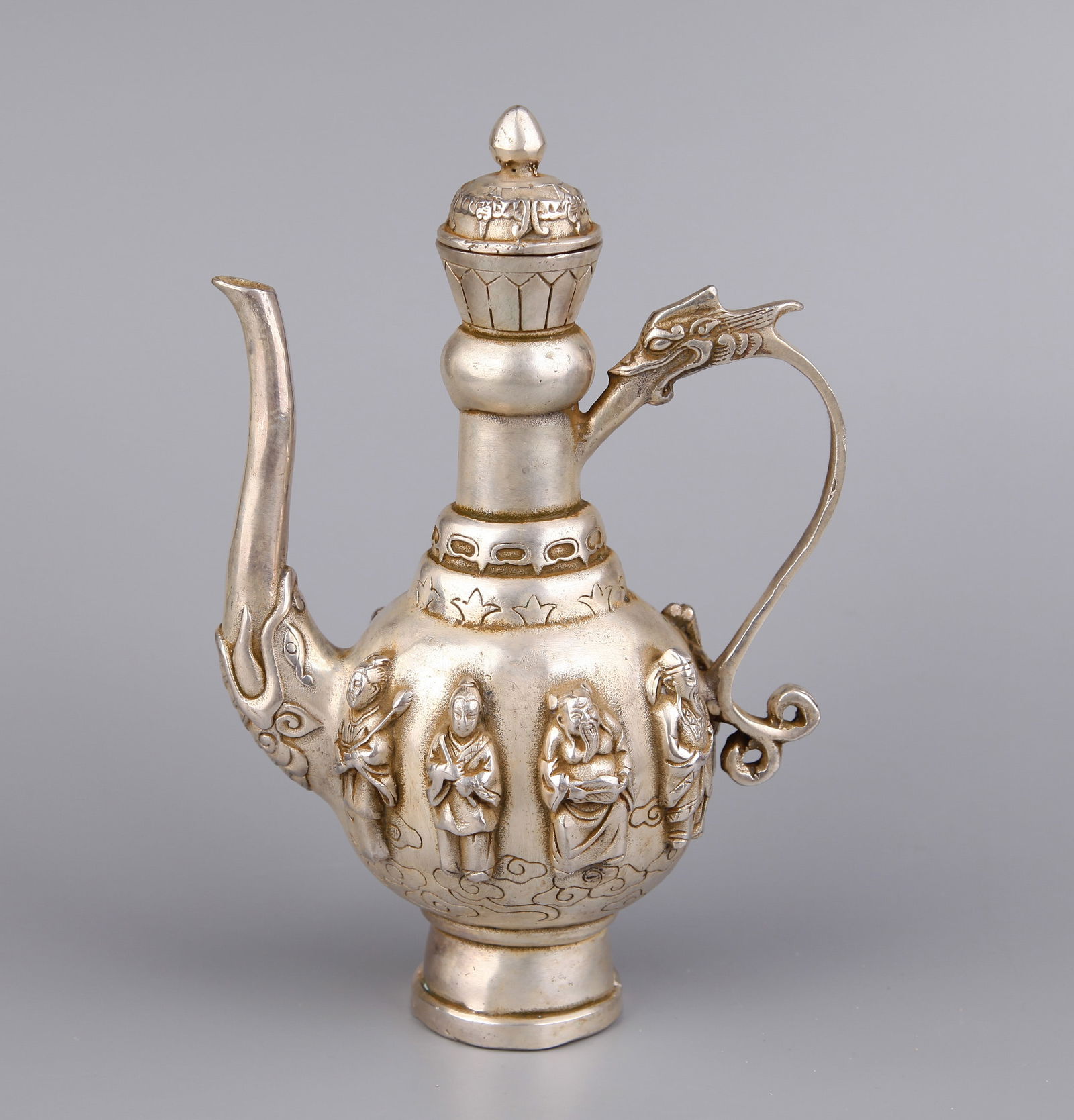 A GILT-SILVER EWER: A gilt-silver ewer and cover decorated with Eight Immortals.Height 20.5 cm.