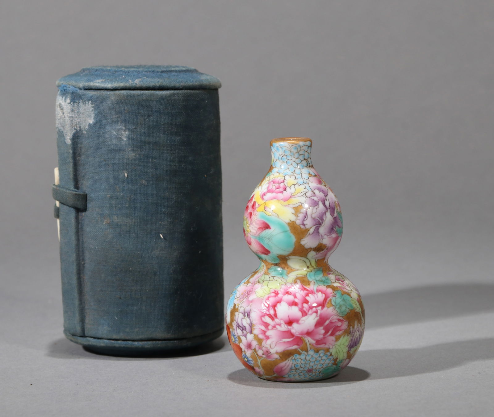 A YANGCAI 'MILLEFLEURS' SNUFF BOTTLE: A Yangcai gourd-shaped snuff bottle decorated with 'millefleurs' design.Height 8 cm.
