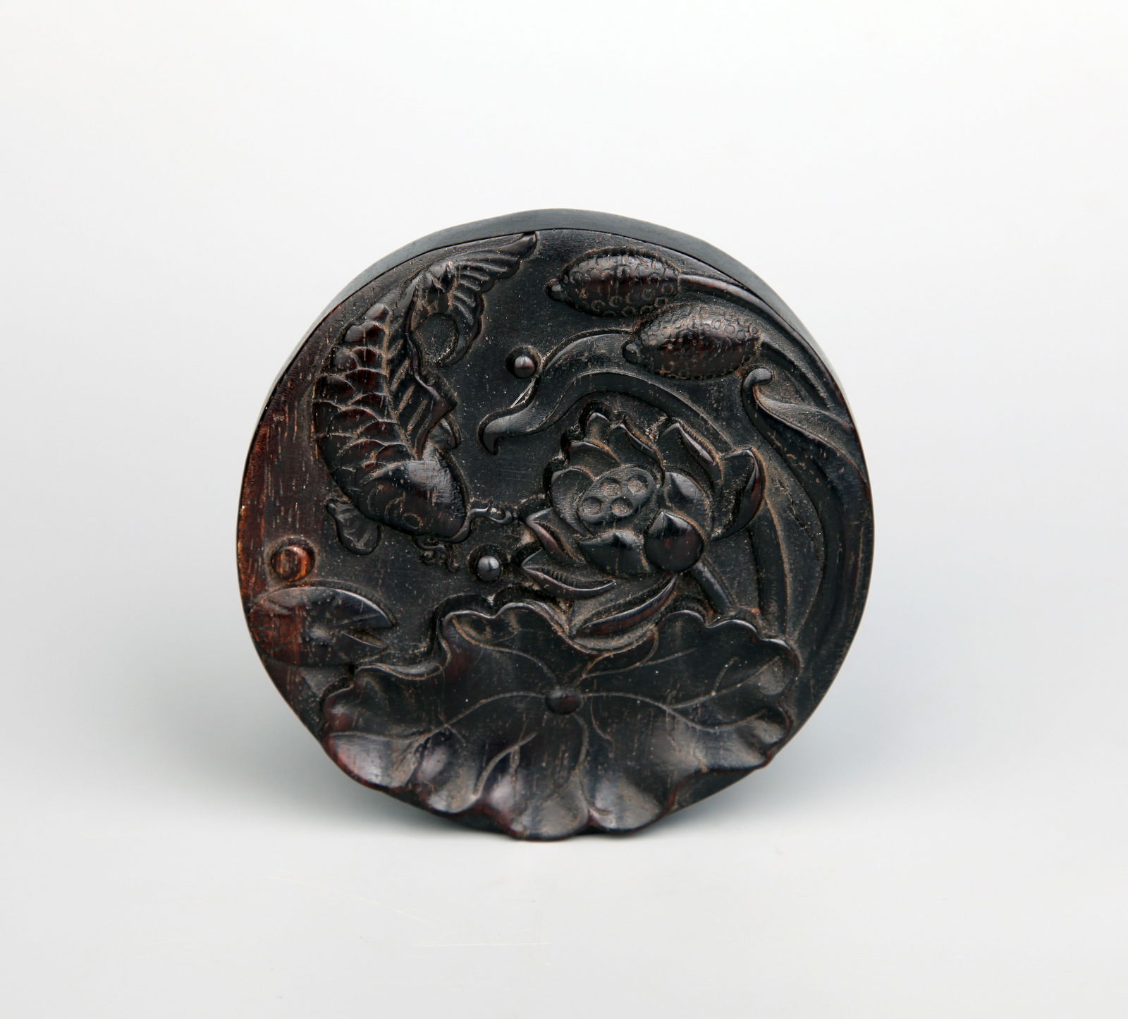 A CARVED SANDALWOOD WASHER: A carved sandalwood washer decorated with 'abundance' design.Height 1.5 cm, Diameter 9.6 cm.