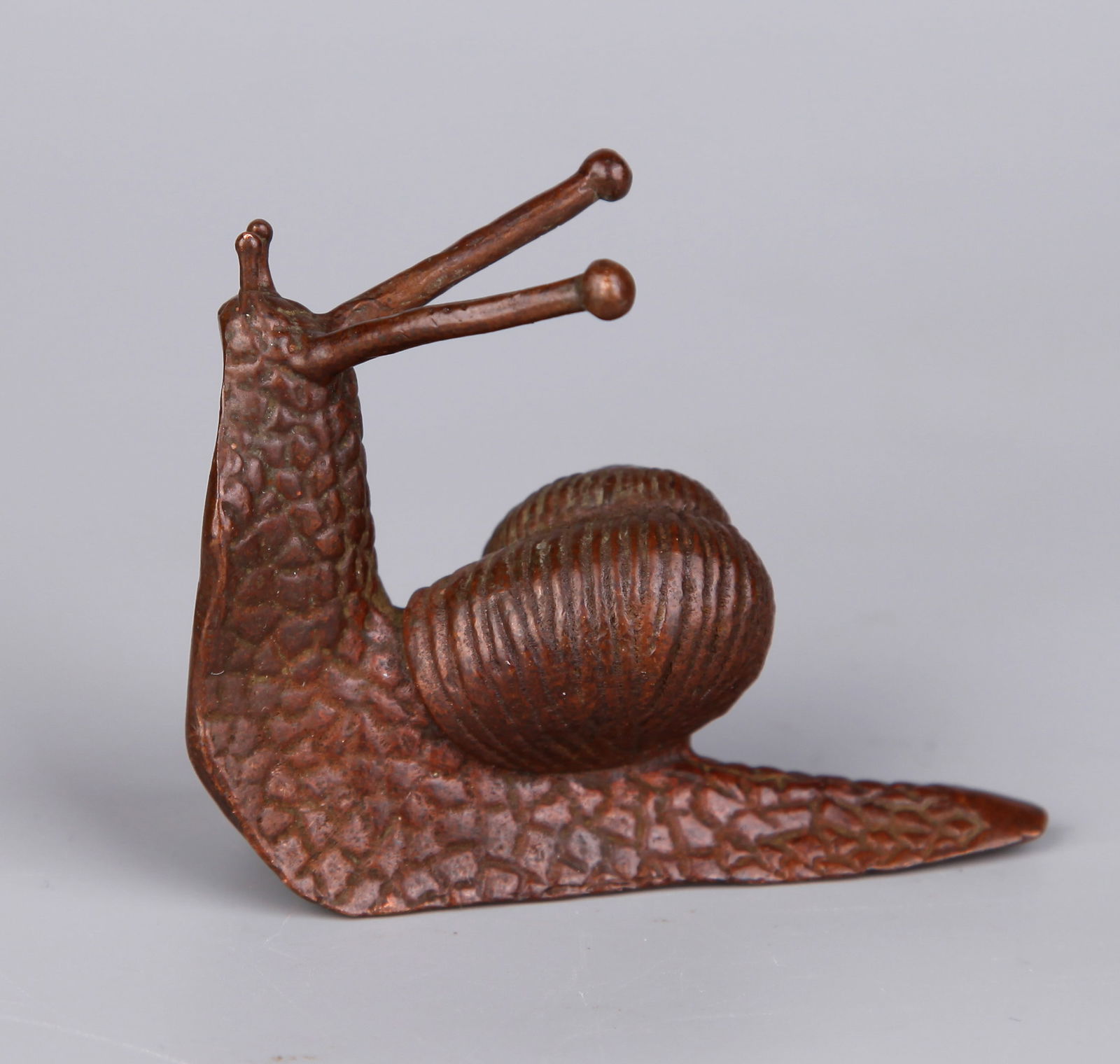 A BRONZE 'SNAIL' PAPERWEIGHT: A bronze paperweight in the shape of a snail.5.5 x 6.5 cm.