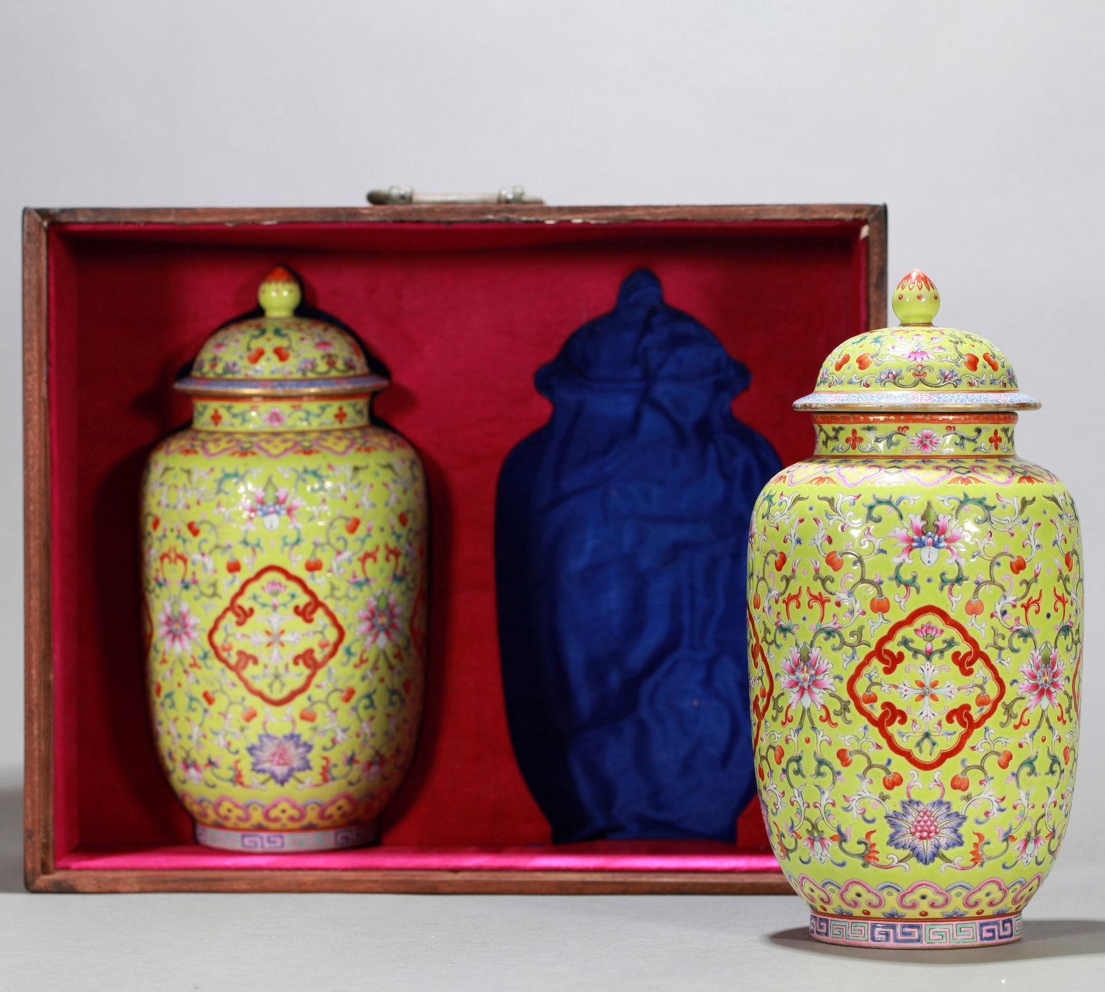 A PAIR OF GREEN-GROUND FAMILLE-ROSE JARS AND COVERS: A pair of green-ground famille-rose jars and covers decorated with flowers. Height 24 cm.