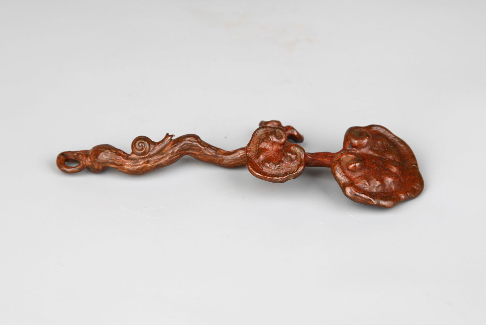 A BRONZE BRUSH REST: A bronze brush rest and incense holder in the shape of Lingzhi fungus.Length 12 cm.