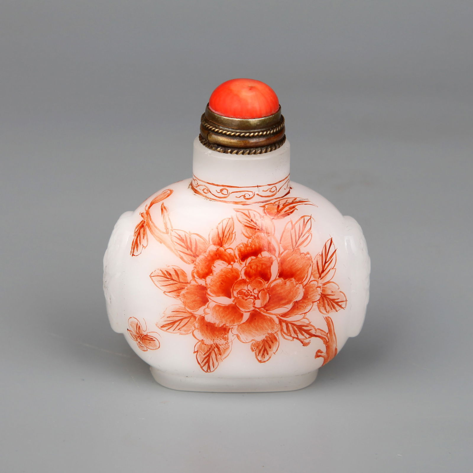 A GLASS SNUFF BOTTLE: A white glass snuff bottle decorated with iron-red floral design.Height 7 cm.