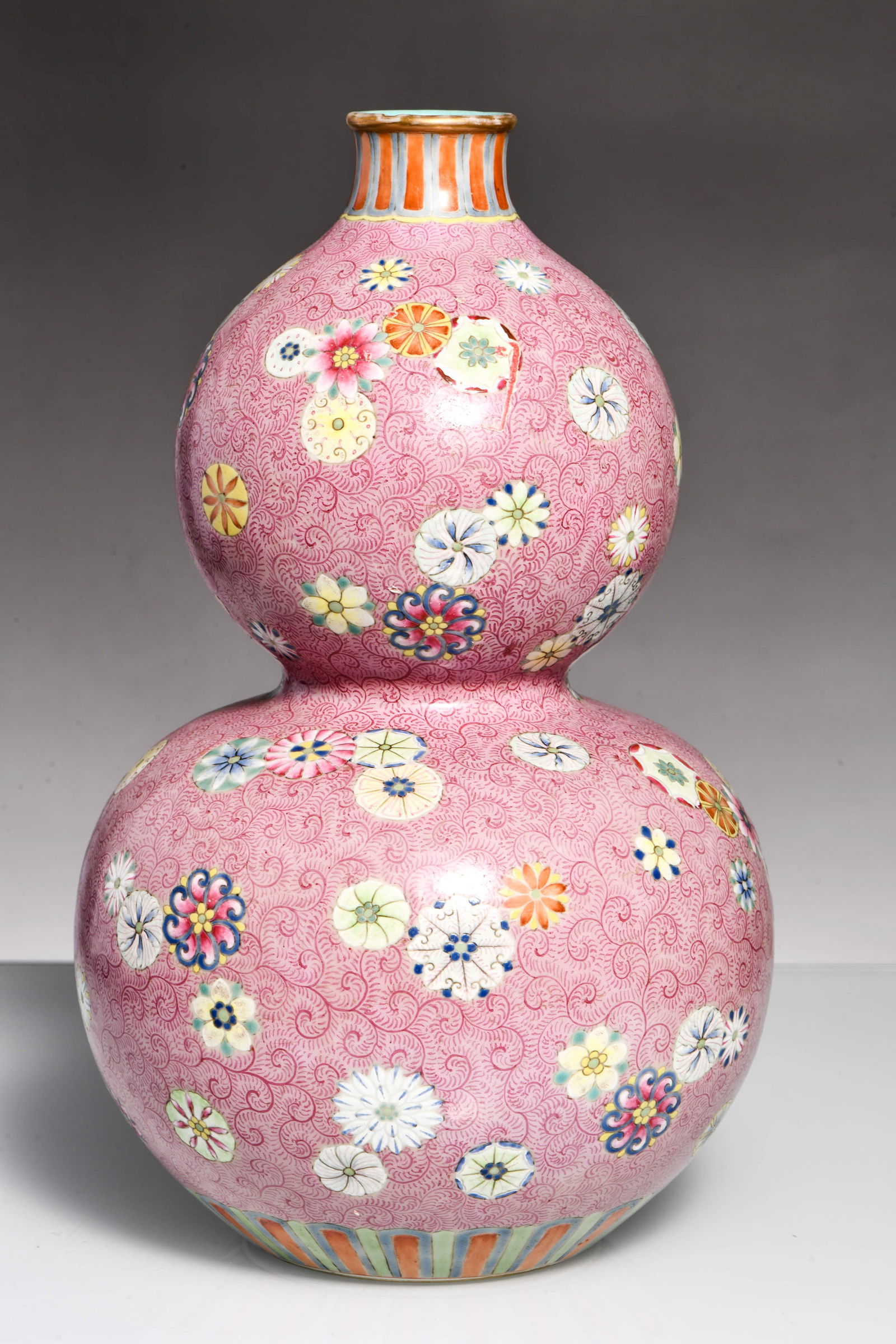 A FAMILLE ROSE 'ROUNDEL FLOWERS' GOURD-SHAPED VASE: A famille rose gourd-shaped vase decorated with roundel flower motifs. Dimensions: Width: 18 cm (7.09 in.), Height: 29 cm (11.42 in.). All measurements are approximate.