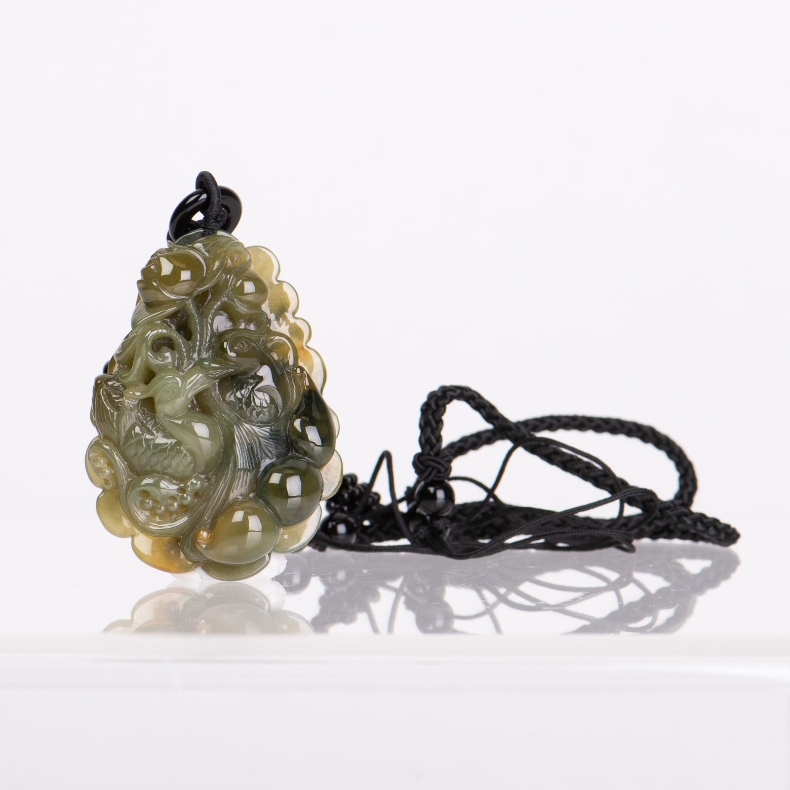 A JADEITE PENDANT NECKLACE CARVED WITH A MANDARIN DUCK: A jadeite pendant necklace carved with a mandarin duck, the stone of green and yellow color.Dimensions: 2.1"h x 0.5"w x 1.5"l (5.33 x 1.27 x 3.81 cm)