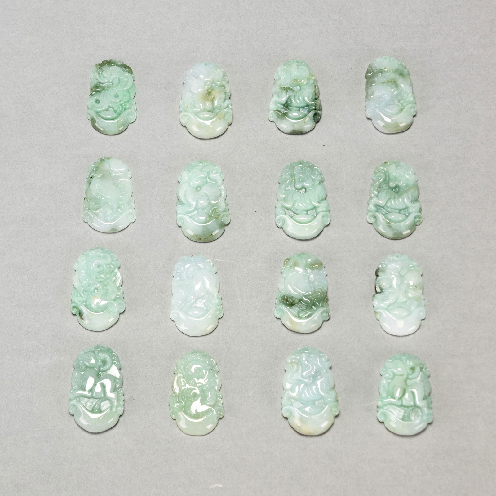 GROUP OF SIXTEEN JADEITE ZODIAC PENDANTS: (Lot of 16) Group of jadeite zodiac pendants.Dimensions: Approx. 1.38"h x 0.79"w x 0.2"l (3.5 x 2 x 0.5 cm)107.3 gross dwt