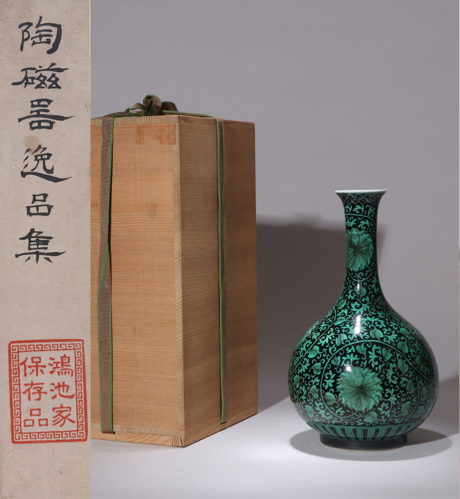 A BLACK-GROUND GREEN-ENAMELLED BOTTLE VASE: A black-ground green-enamelled bottle vase decorated with interlocking flowers.Height 21 cm.Note: By repute, from the collection of Baron Konoike of Japan. The family collection catalog is not