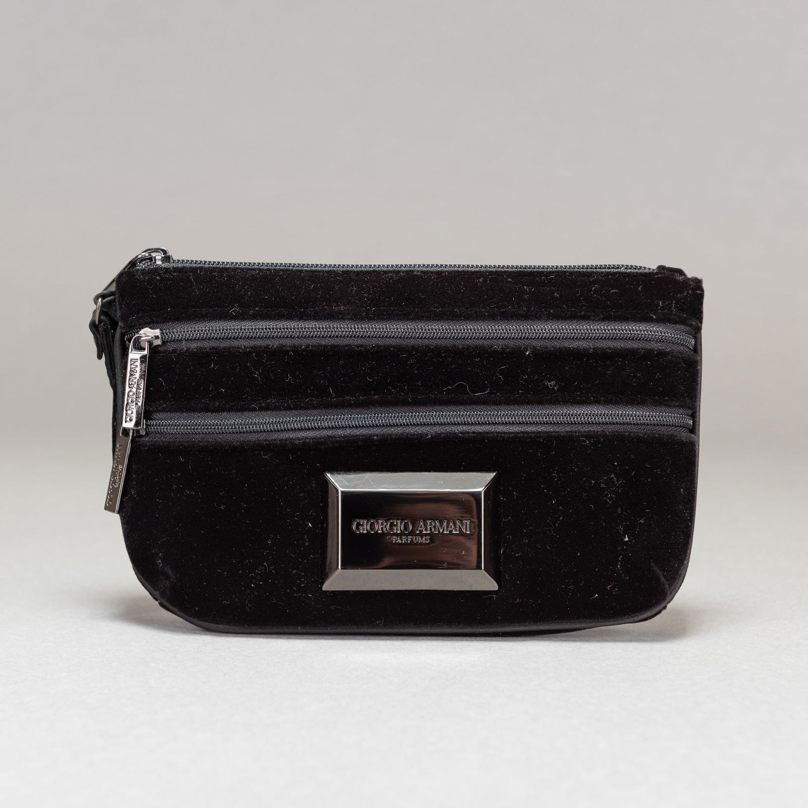 GIORGIO ARMANI BLACK VELVET CLUTCH: Giorgio Armani velvet clutch black bag, 3 pockets with embossed zip, silver plate. Comes with box. 7.9"h x 5.1"w (20 x 13 cm) Condition: Pre-owned. Excellent condition.