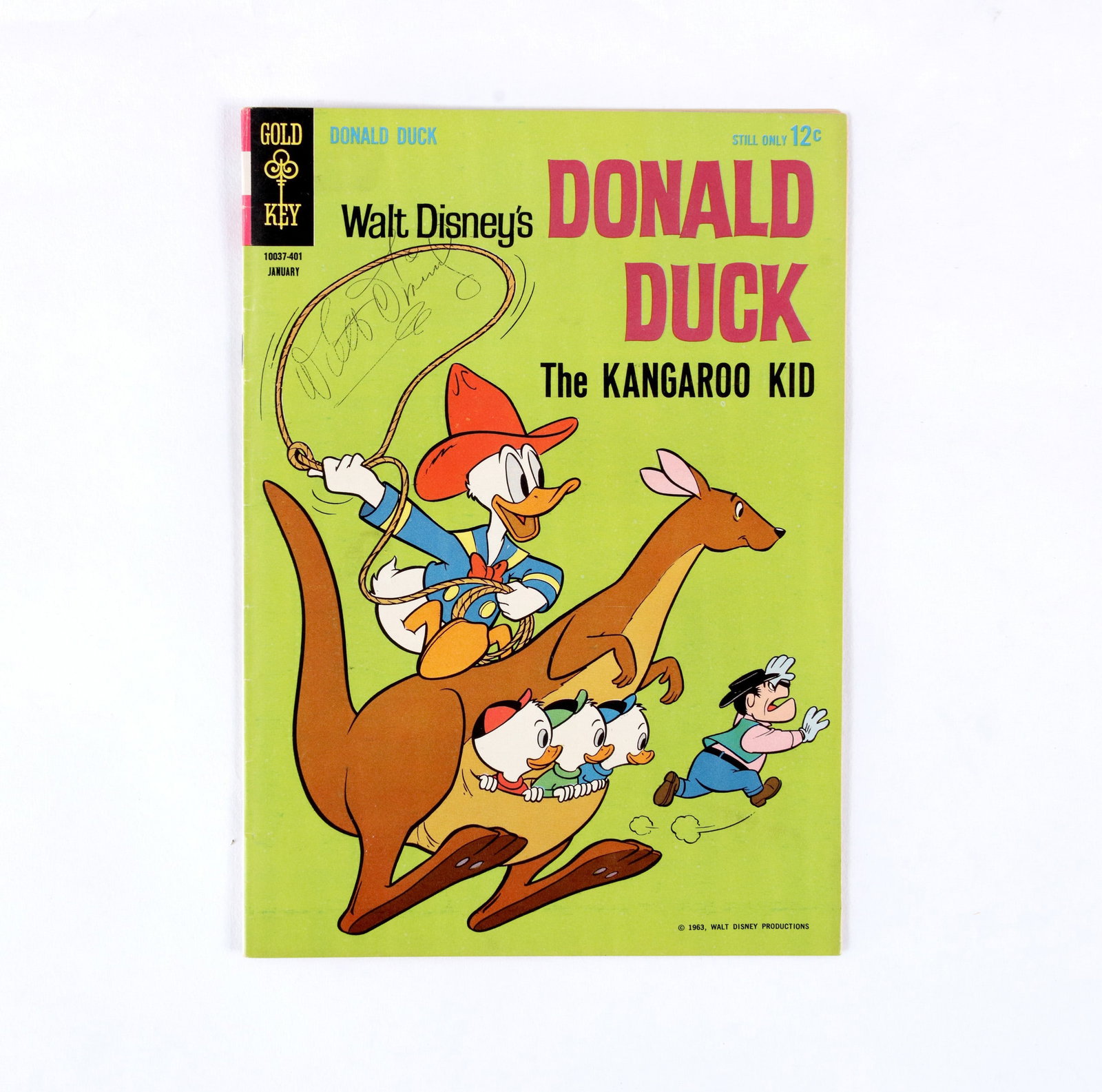 COMIC BOOK "DONALD DUCK" (1963) BEARING SIGNATURE ATTRIBUTED TO WALT DISNEY: A period comic book featuring Donald Duck. The cover depicts characters riding a kangaroo, with a printed price of 12 cents. The front cover features the name attributed to Walt Disney, written direct