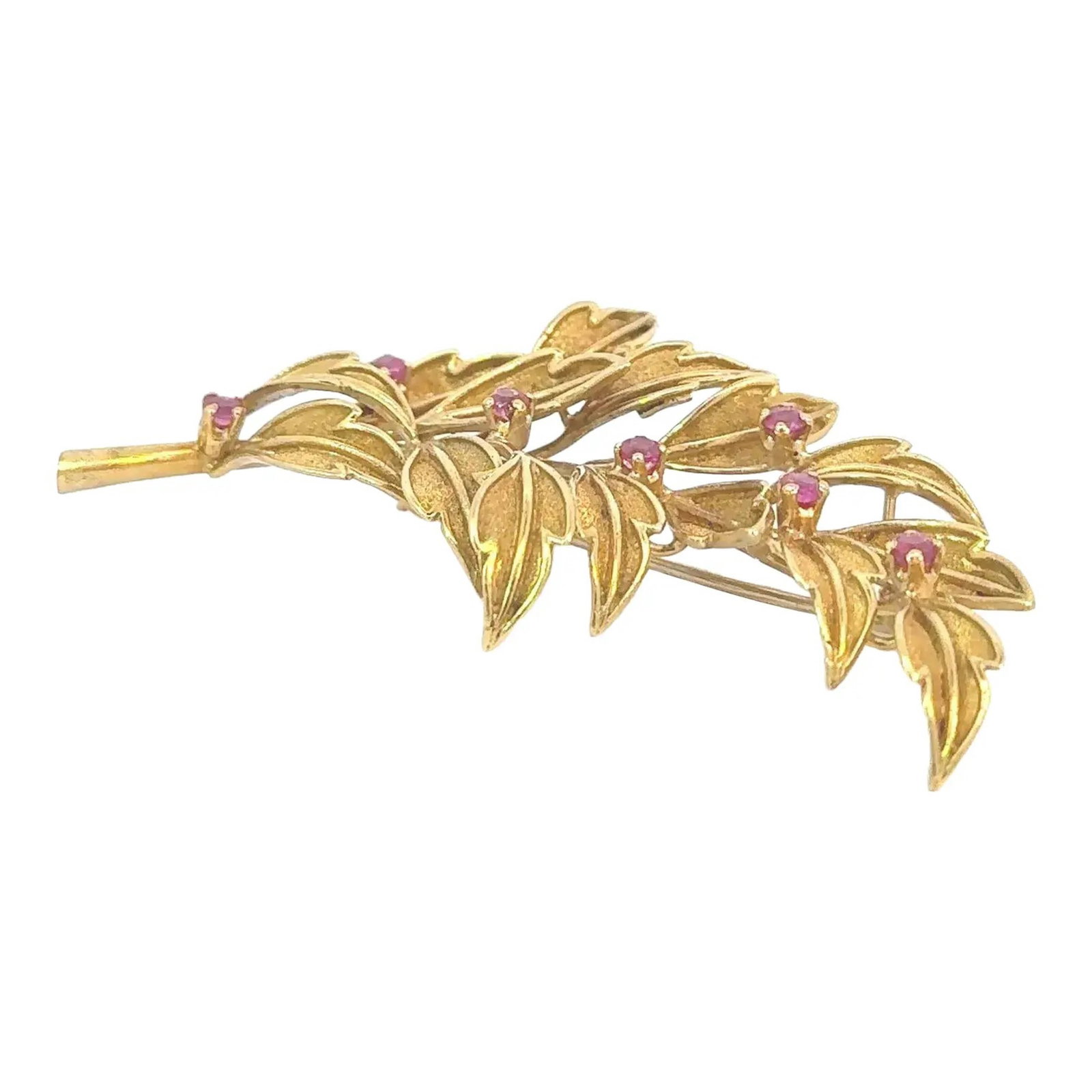 GOLD-TONE LEAF BROOCH WITH PINK GEMSTONE ACCENTS: The brooch is designed as a stylized spray of leaves, arranged in an asymmetrical composition. Interspersed among the leaves are small round pink gemstones. The reverse is fitted with a standard pin