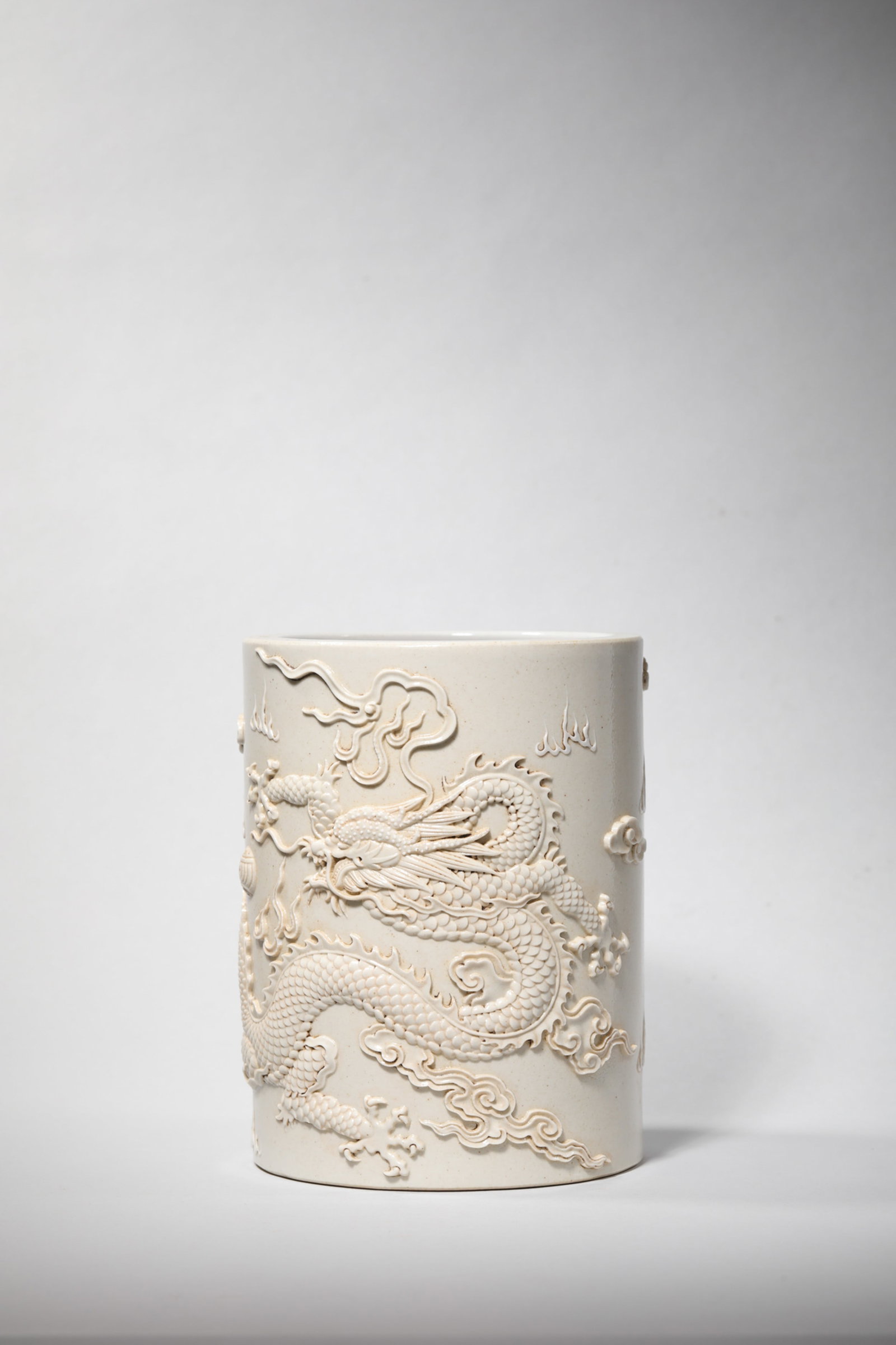 A RELIEF-DECORATED WHITE-GLAZED 'DRAGON' BRUSH POT (1 of 7)