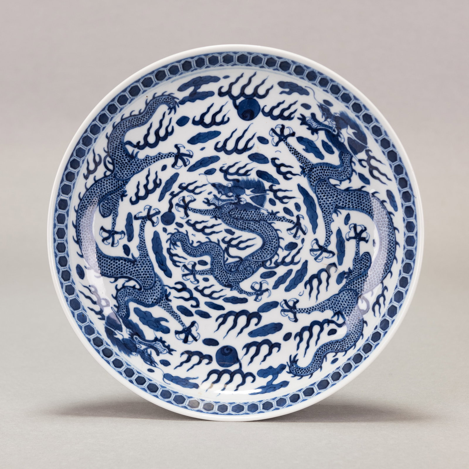 CHINESE BLUE AND WHITE DRAGON CHARGER, GUANGXU MARK AND PERIOD: Chinese blue and white dragon charger, Guangxu mark and period, the well-potted body with shallow rounded sides rising from a slightly tapered foot to a slightly flared rim, centered with a