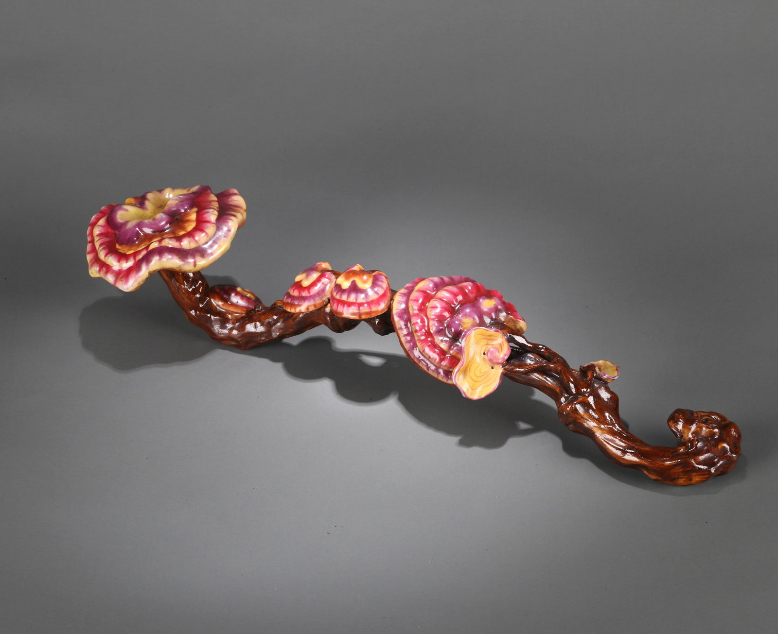 A PORCELAIN IMITATION LINGZHI FUNGUS RUYI SCEPTER: A porcelain Ruyi scepter in imitation of Lingzhi fungus. Length 32 cm.
