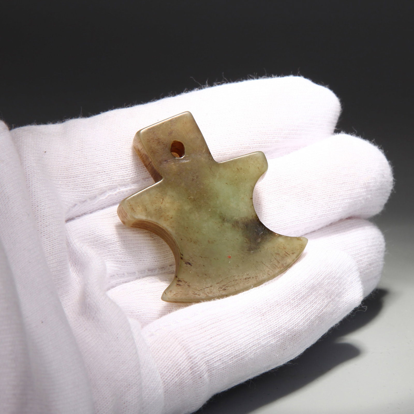 A JADE 'AXE' PENDANT: A jade pendant carved in the shape of an axe. Length 3.9 cm, Weight 9.35 g.