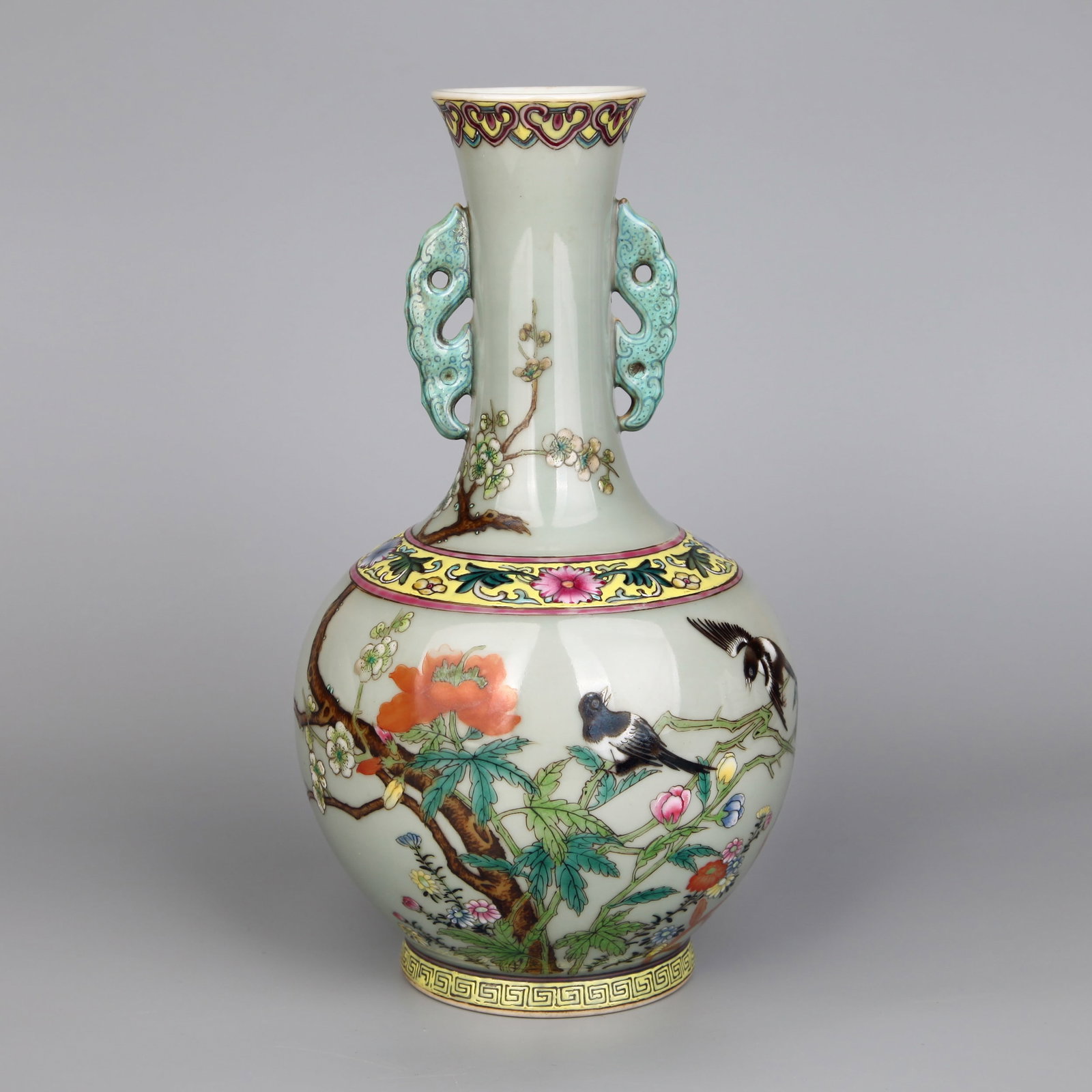 A CELADON-GLAZED FAMILLE ROSE 'BIRDS AND FLOWERS' VASE: A celadon-glazed famille rose vase with dragon handles, decorated with birds and flowers. Note: By repute, from Beijing Jiuge Autumn Auction, 2020.