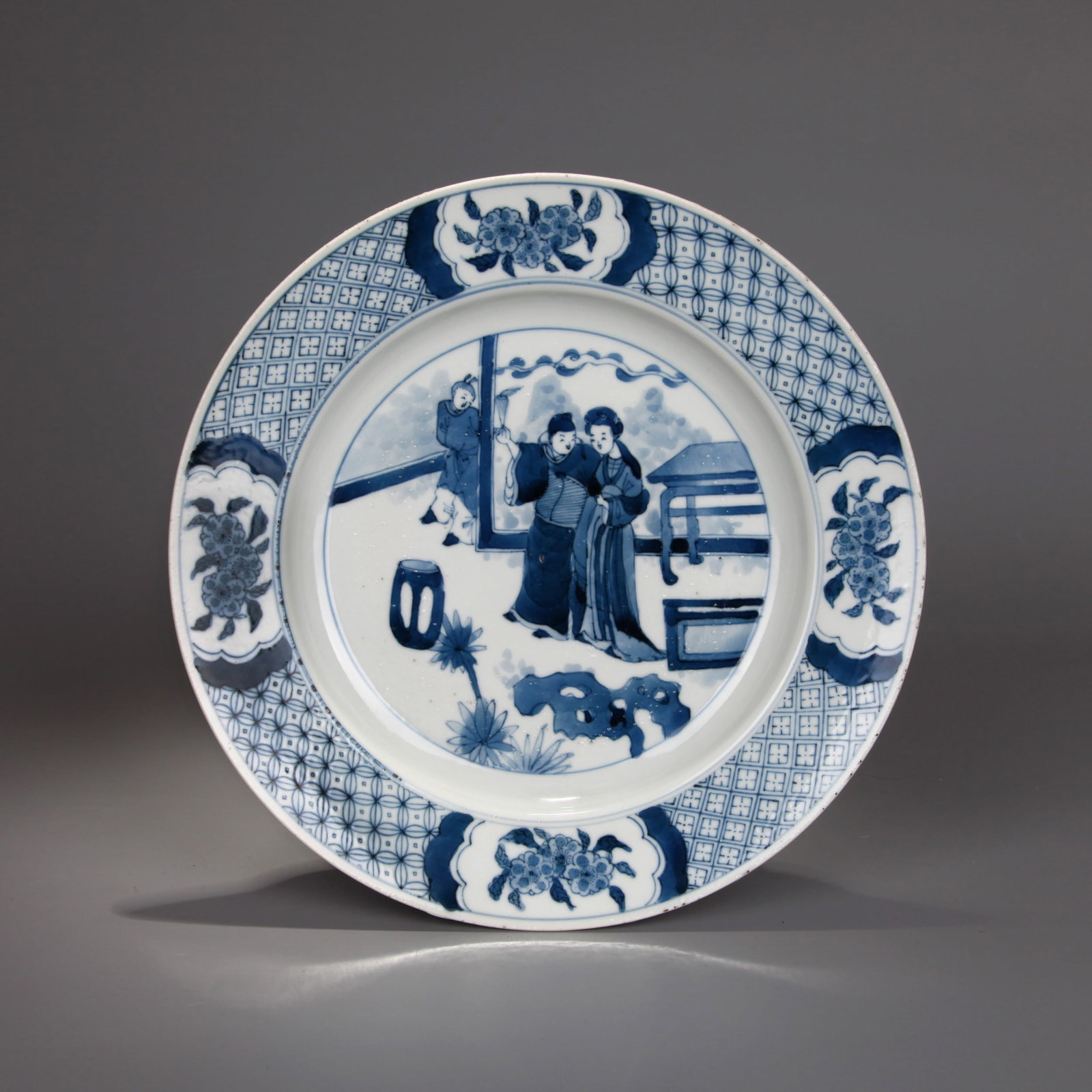 A BLUE AND WHITE 'FIGURES' DISH: A blue and white dish decorated with three figures in a scene.