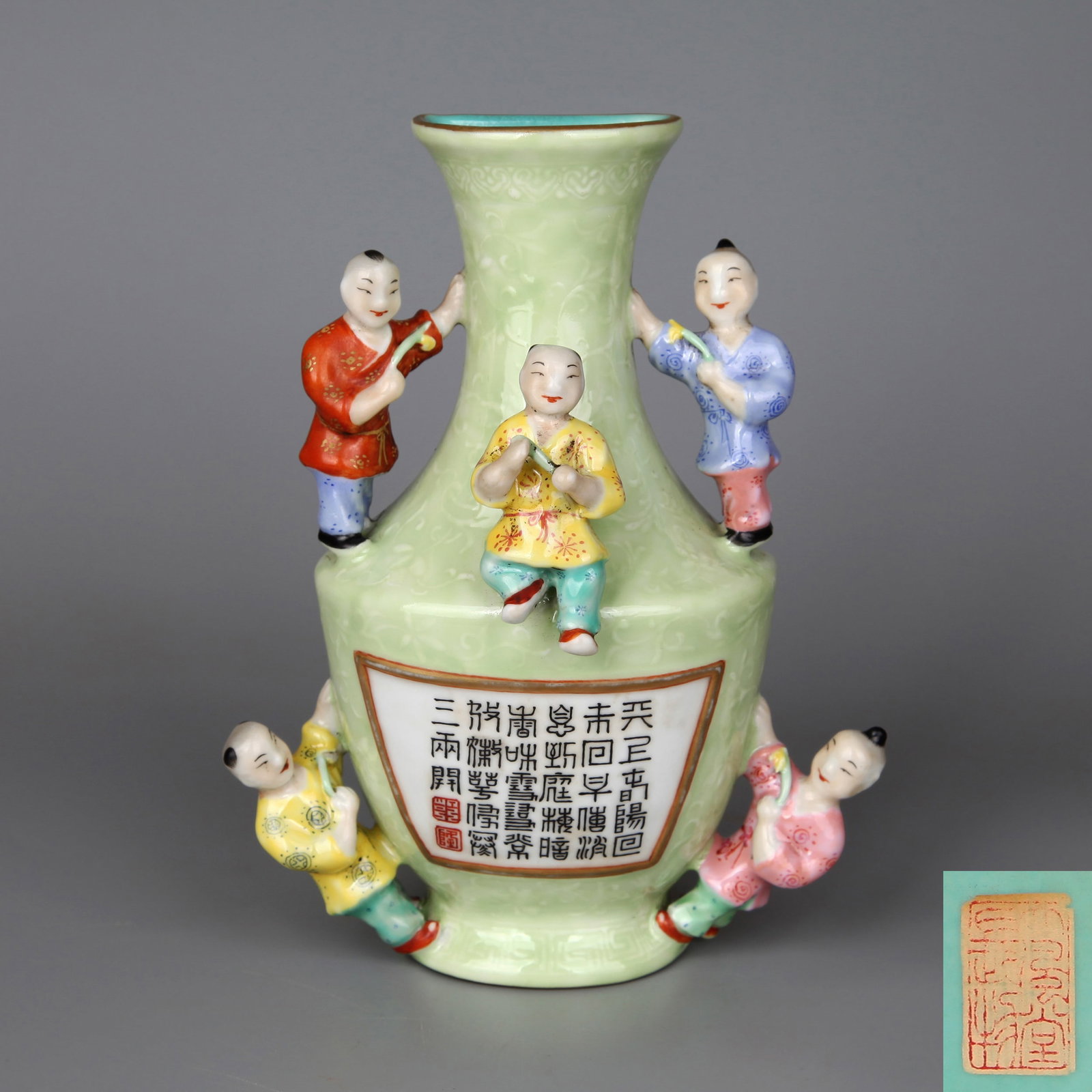 A GREEN-GROUND 'FIVE BOYS' WALL VASE WITH POEMS: A wall vase moulded with five boys on an ochre-green ground, inscribed with imperial poems. No floral decoration. Note: By repute, from the collection of Dafengtang (Zhang Daqian).