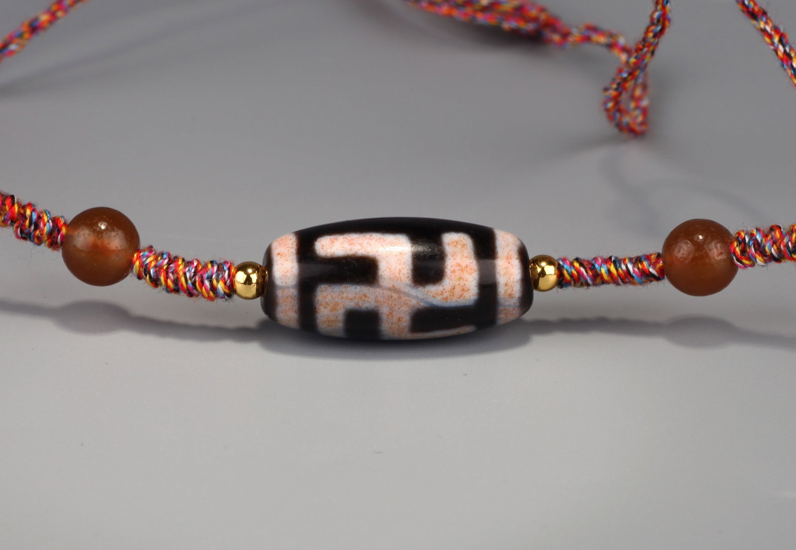 A DZI BEAD WITH 'WAN' MOTIF (1 of 8)