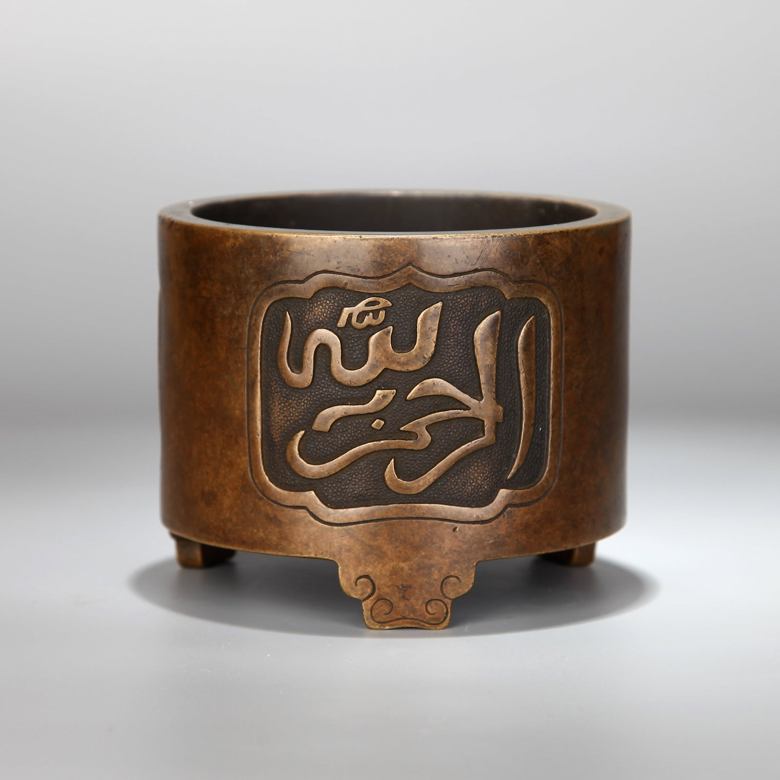 A BRONZE CENSER WITH ARABIC SCRIPT: A bronze censer decorated with Arabic script.