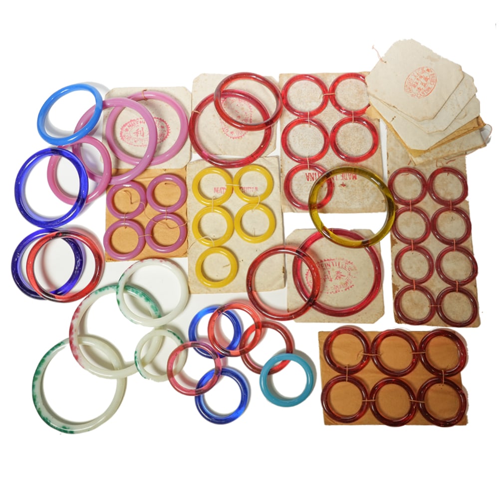 GROUP OF 50 PEKING GLASS BANGLES, LATE QING OR REPUBLIC PERIOD: (lot of 50) Group of Peking glass bangles, late Qing or Republic period. Largest: 3.46"d (8.8 cm) Provenance: Property from the Estate of Gloria Hebert, Santa Barbara, California.