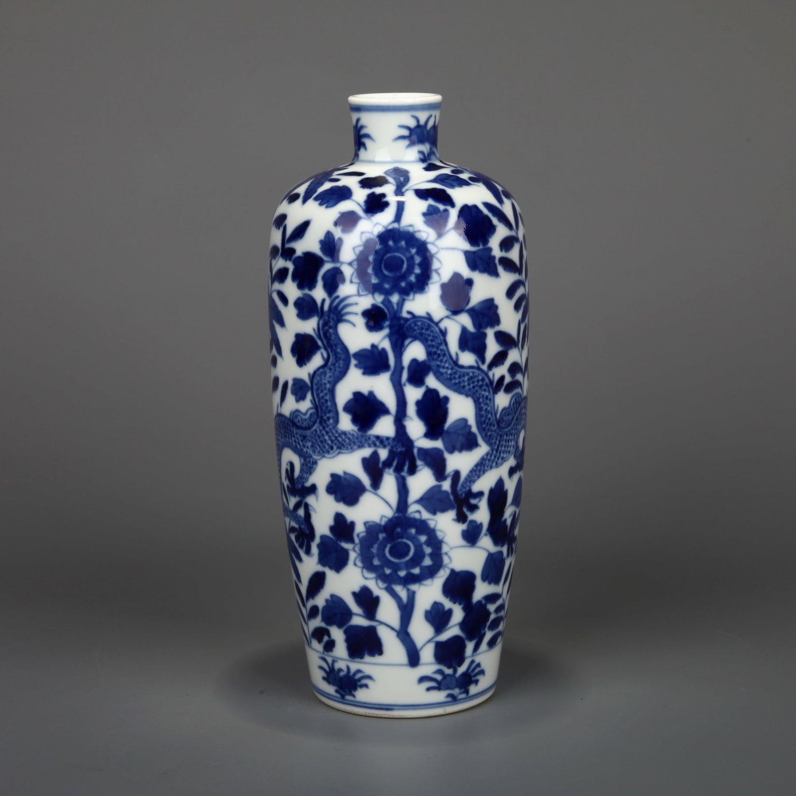 A BLUE AND WHITE 'DRAGON AND FLOWER' VASE: A blue and white vase decorated with dragon and flower design. Height 22 cm, width 9.5 cm.