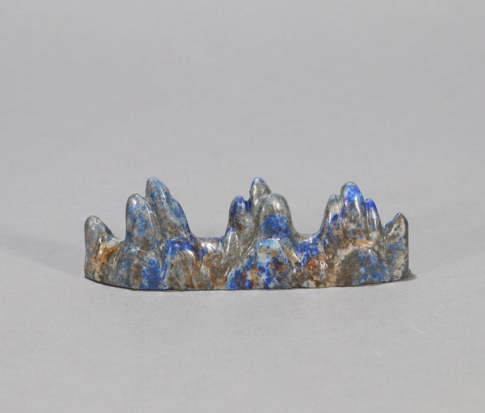 A LAPIS LAZULI BRUSH REST: A lapis lazuli brush rest. Length 11 cm, height 4 cm.