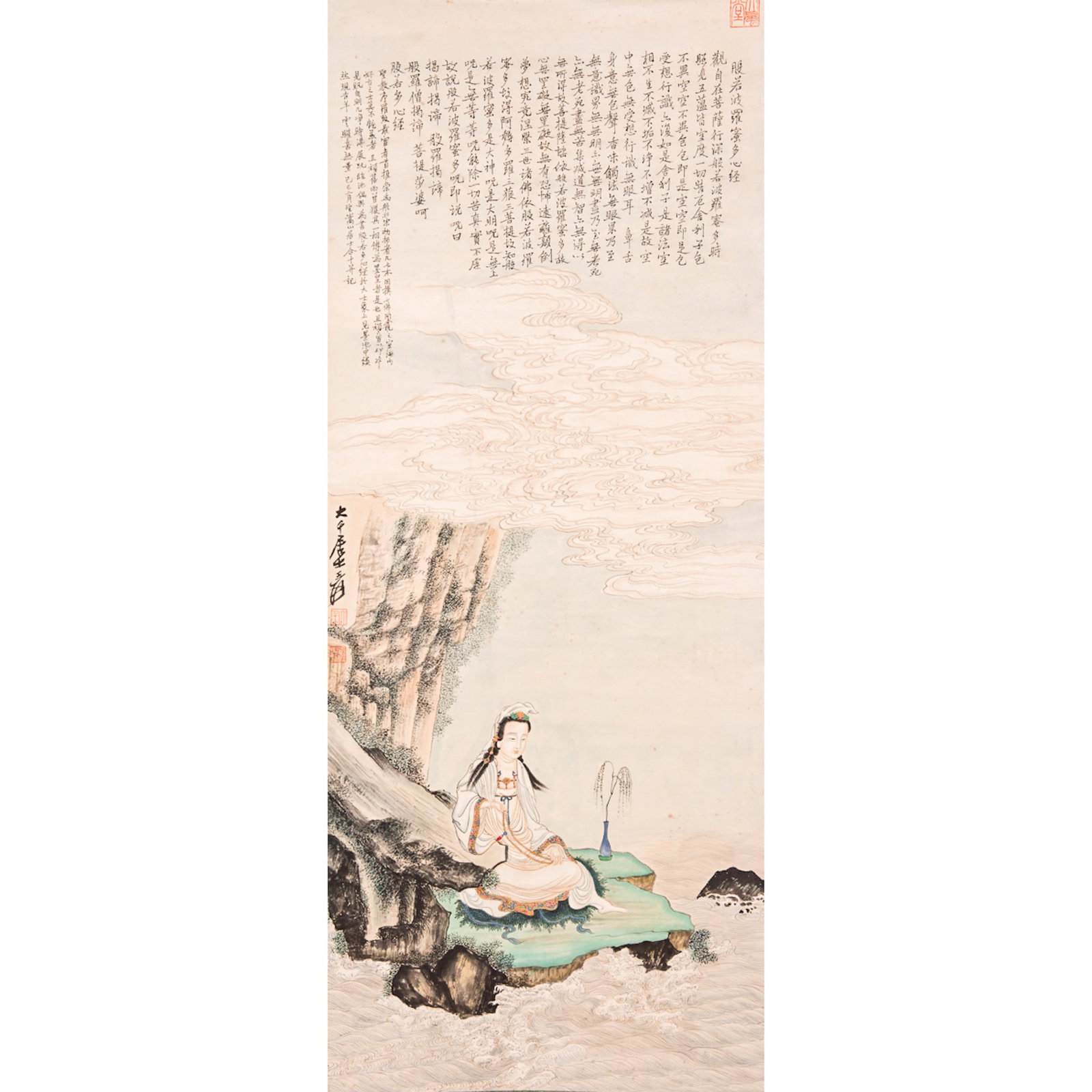 A CHINESE PAINTING OF GUANYIN BY THE SHORE: A Chinese painting of Guanyin by the shore, ink and color on paper, depicting Guanyin seated by a rocky shore beneath the mountains, gazing at waves, with a long inscription at top, attributed to Zhan