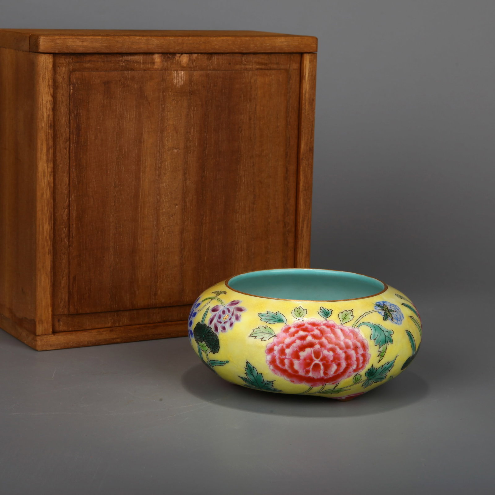 A YELLOW-GROUND FAMILLE-ROSE 'FLORAL' WATER POT: A yellow-ground famille-rose water pot with flowers. Height 5 cm, maximum diameter 11.5 cm. Note: With a Japanese wood box.