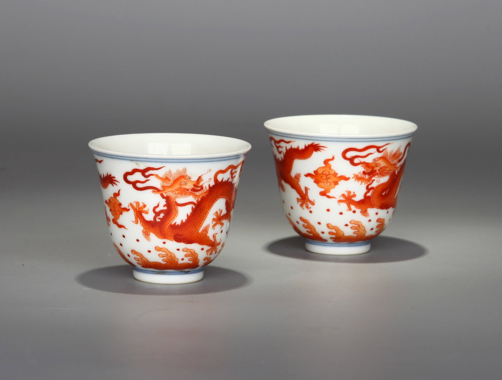 A PAIR OF IRON-RED 'TWO DRAGONS PURSUING A FLAMING PEARL' CUPS: A pair of iron-red cups, each decorated with two dragons pursuing a flaming pearl. Height 5 cm, diameter 6 cm.