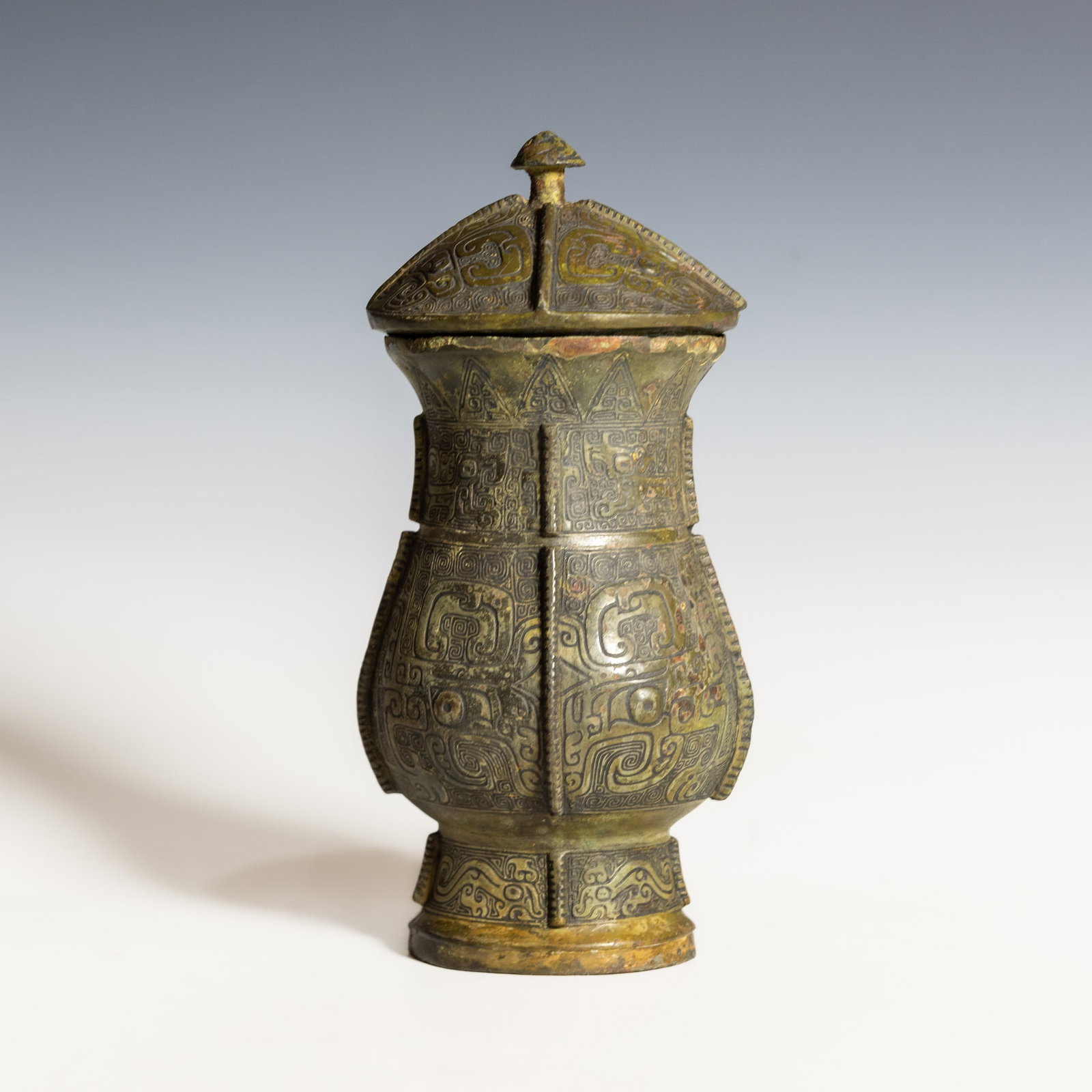 CHINESE ARCHAISTIC BRONZE RITUAL WINE VESSEL AND COVER, PROBABLY SHANG DYNASTY: Chinese archaistic bronze ritual wine vessel and cover, probably Shang dynasty. 7.48"h x 3.74"w x 3.35"d (19 x 9.5 x 8.5 cm)