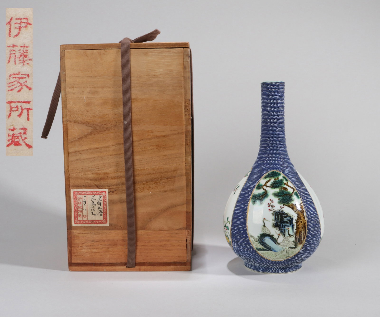 A FAMILLE-ROSE LONG-NECK VASE WITH FOUR PANELS: A famille-rose long-neck vase decorated with four reserved panels. Height 29 cm. Note: By repute, from the Ito family collection.